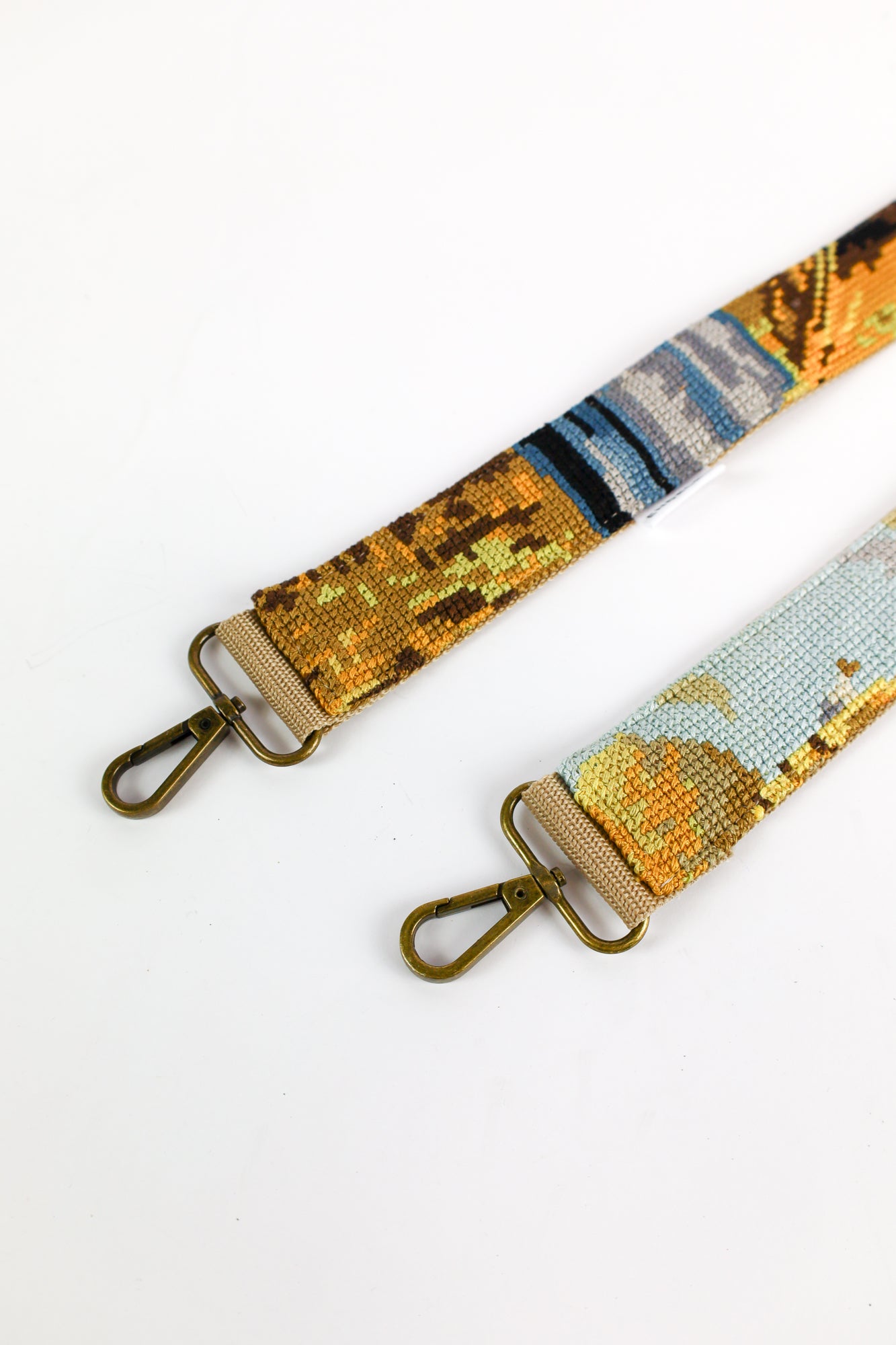 Strap made from a painting illustrating working farmers, with a mix of yellow, blue, green, brown, and a small pink accent, a unique addition to your bag, phone, or camera.