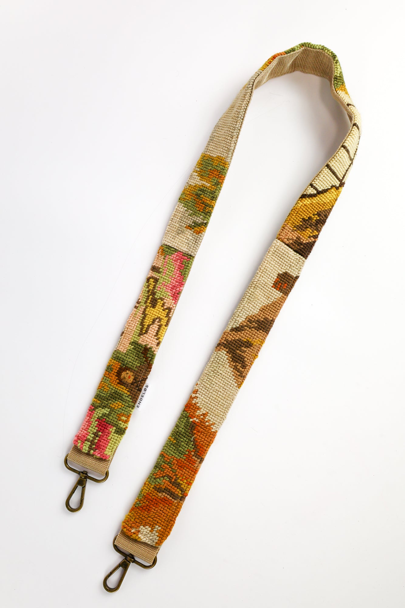 Handgemaakte strap van geborduurd schilderij met een schapenhoeder op een bloeiend veld, perfect voor tas, telefoon of camera.