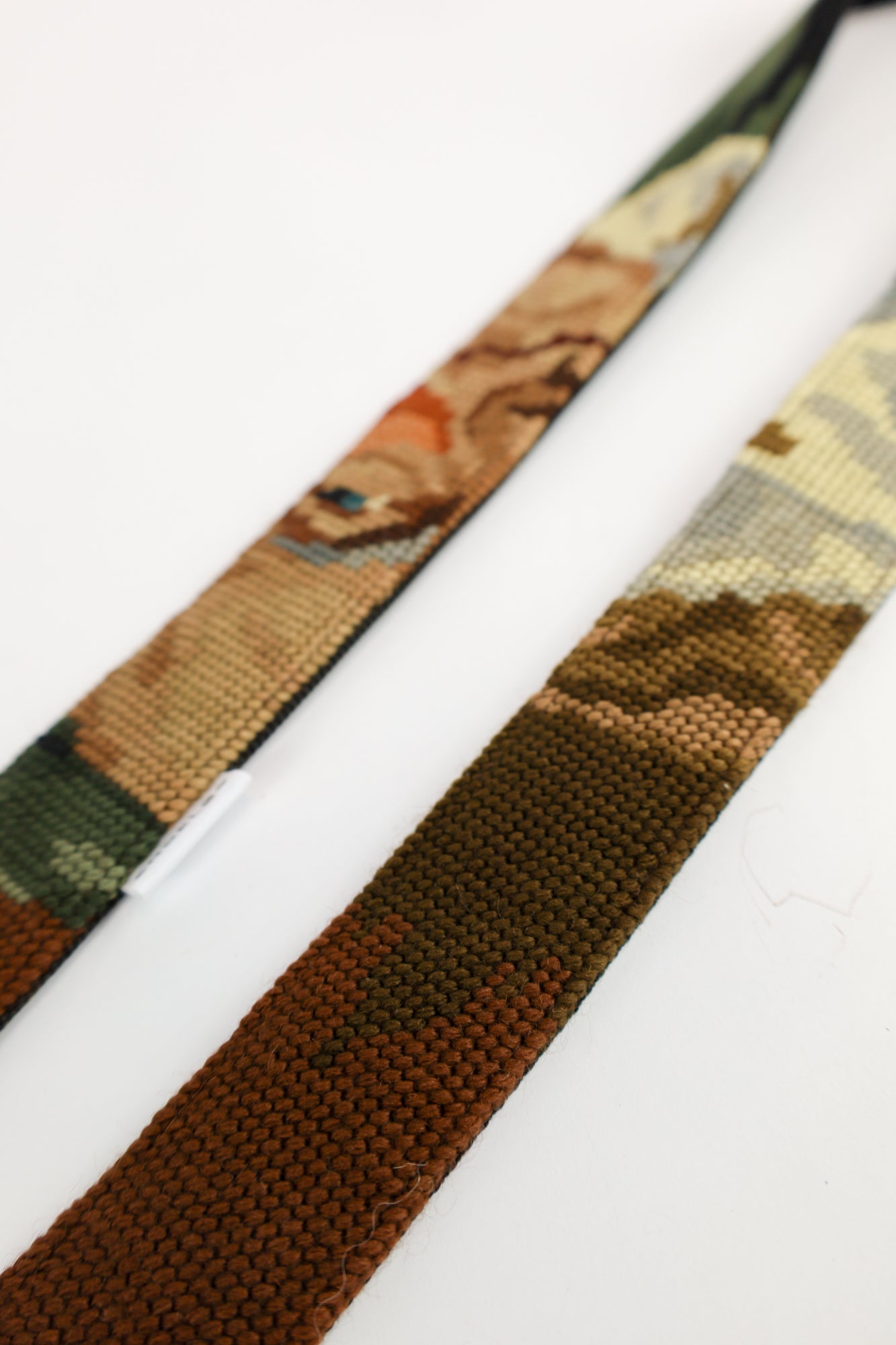 Strap gemaakt van een geborduurd schilderij van een drinkende man, met donkere kleuren die een mystieke flair aan je accessoires geven.