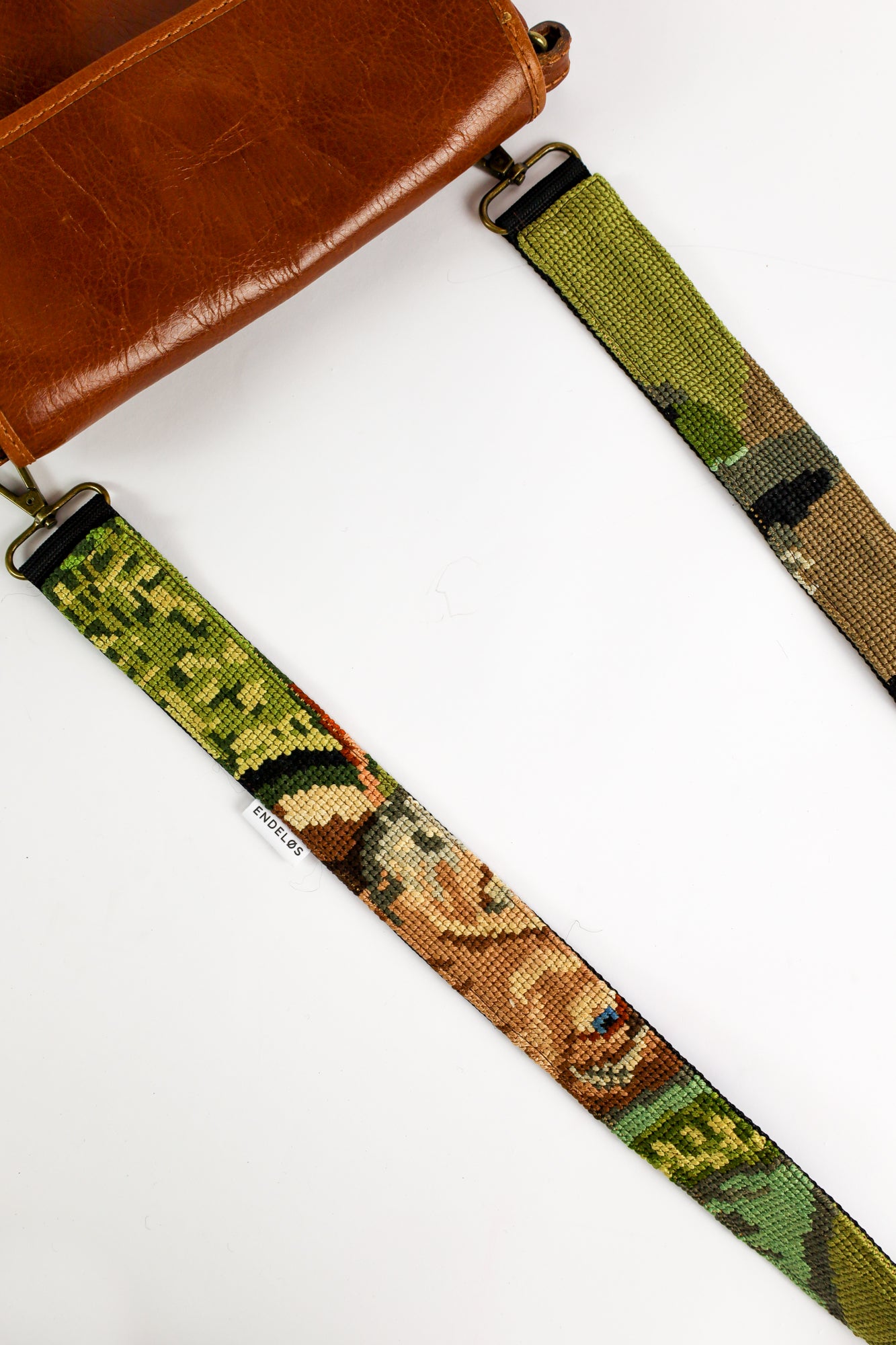 Handgemaakte strap met een borduurwerk van een man met een pijp in groene tinten, voegt karakter toe aan je tas, telefoon of camera.