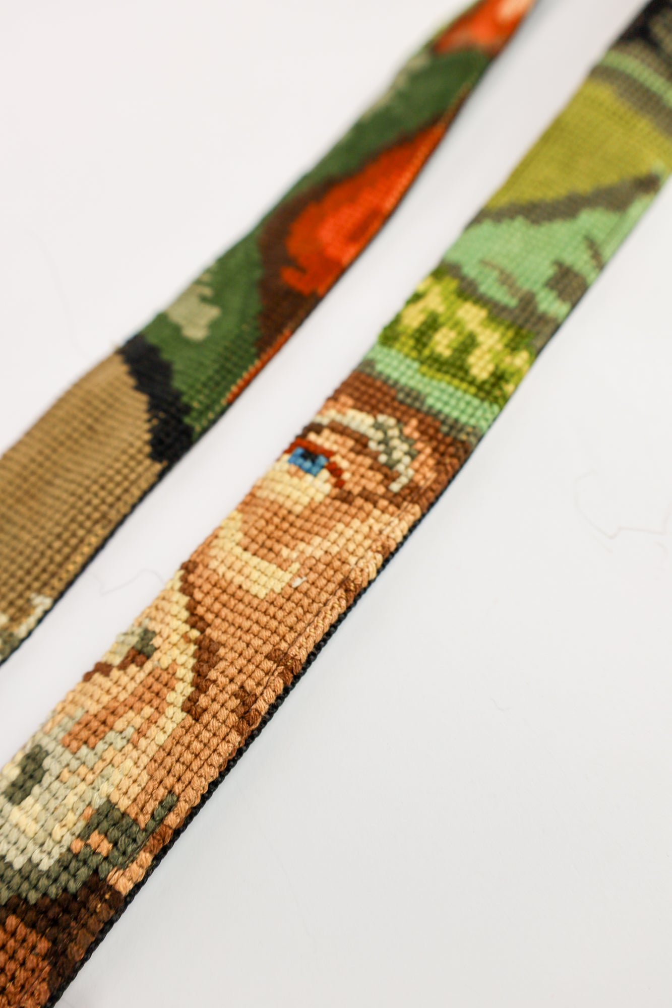 Duurzame strap gemaakt van hergebruikte materialen, met een uniek borduurwerk van een man met een pijp in groene tinten.