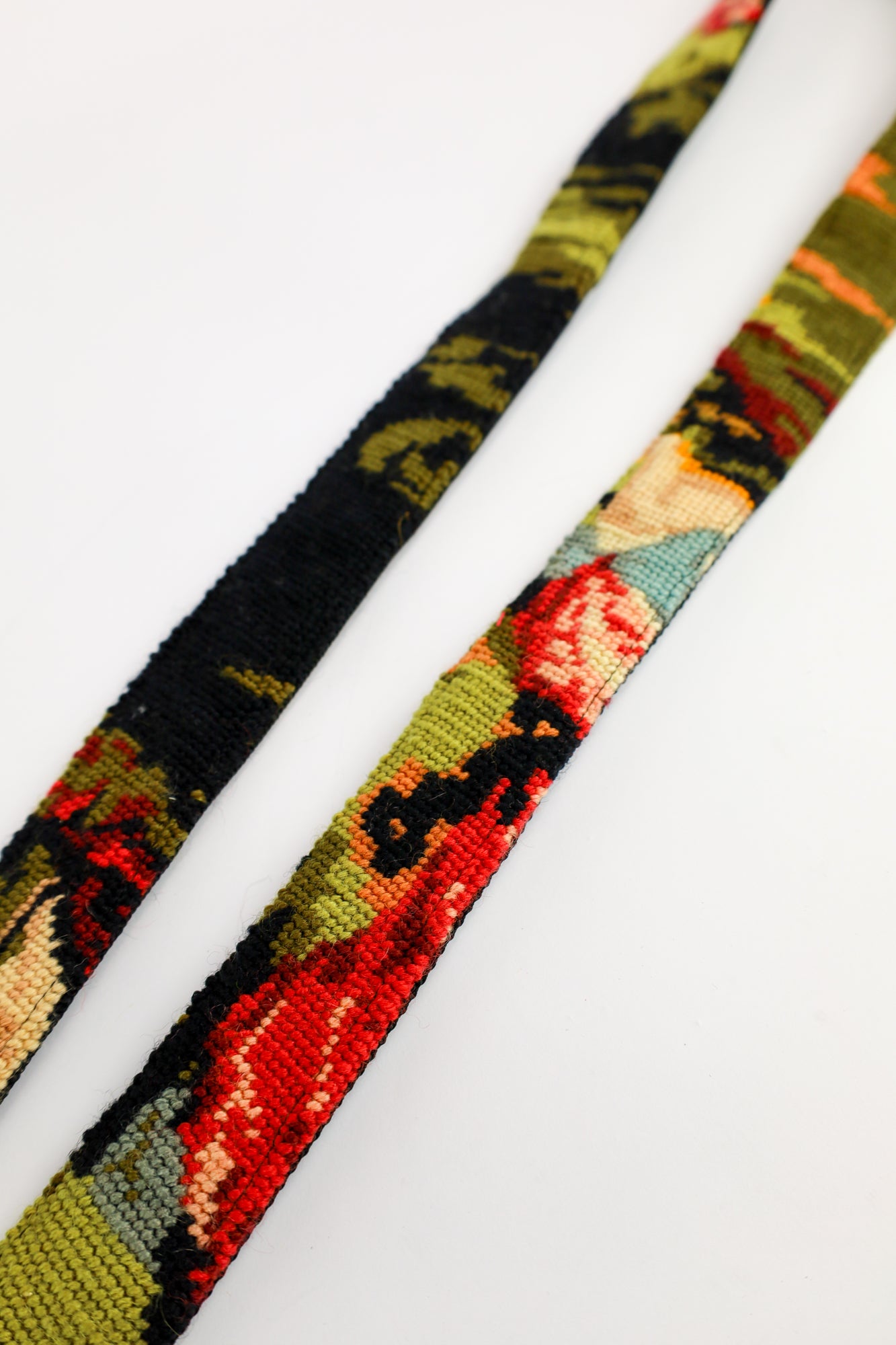 Handgemaakte strap featuring an embroidered vintage painting with vibrant orange hues, adding style and personality.