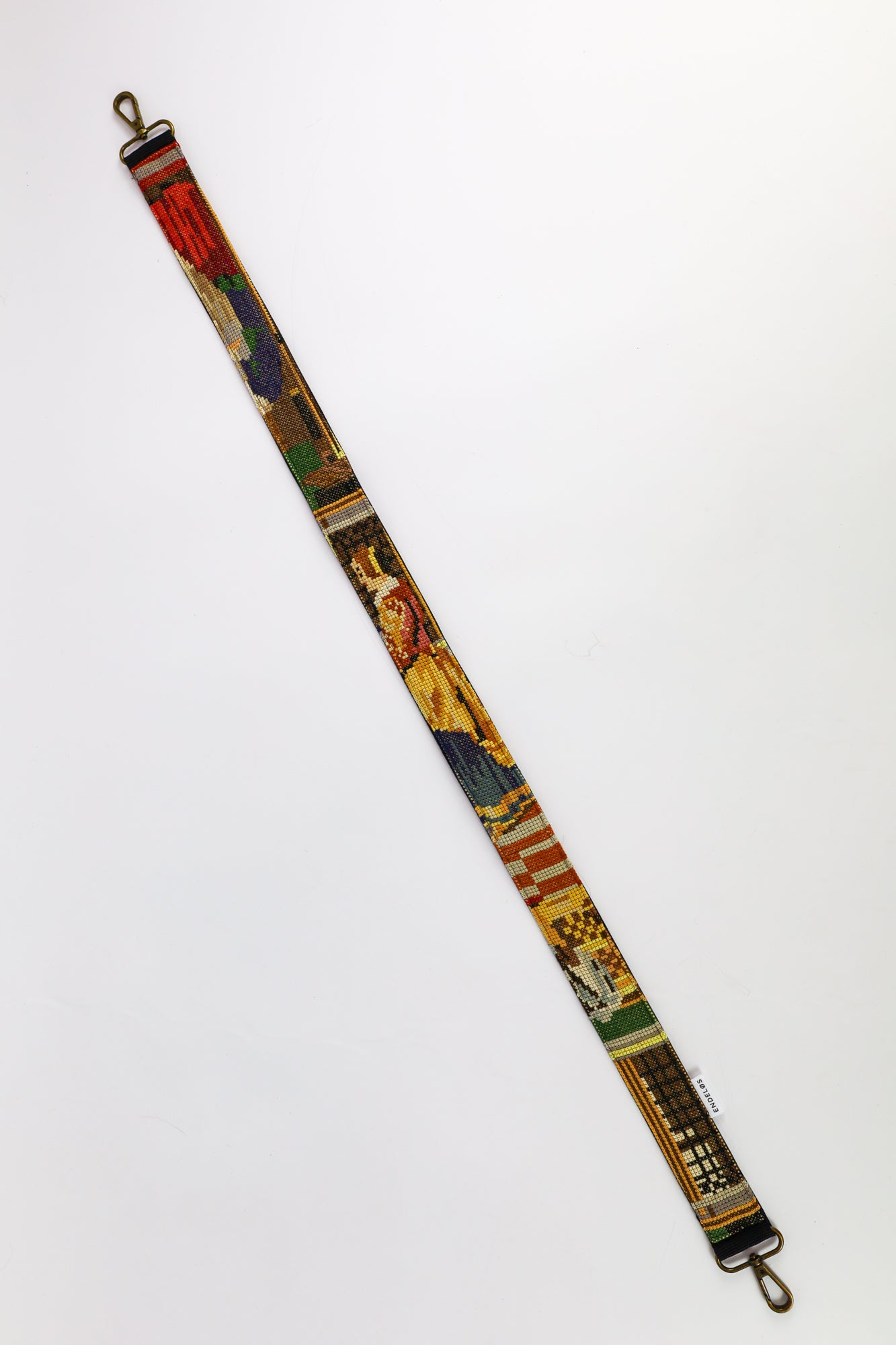 Handcrafted strap featuring an embroidery of a couple doing laundry with a cleaner in the background.