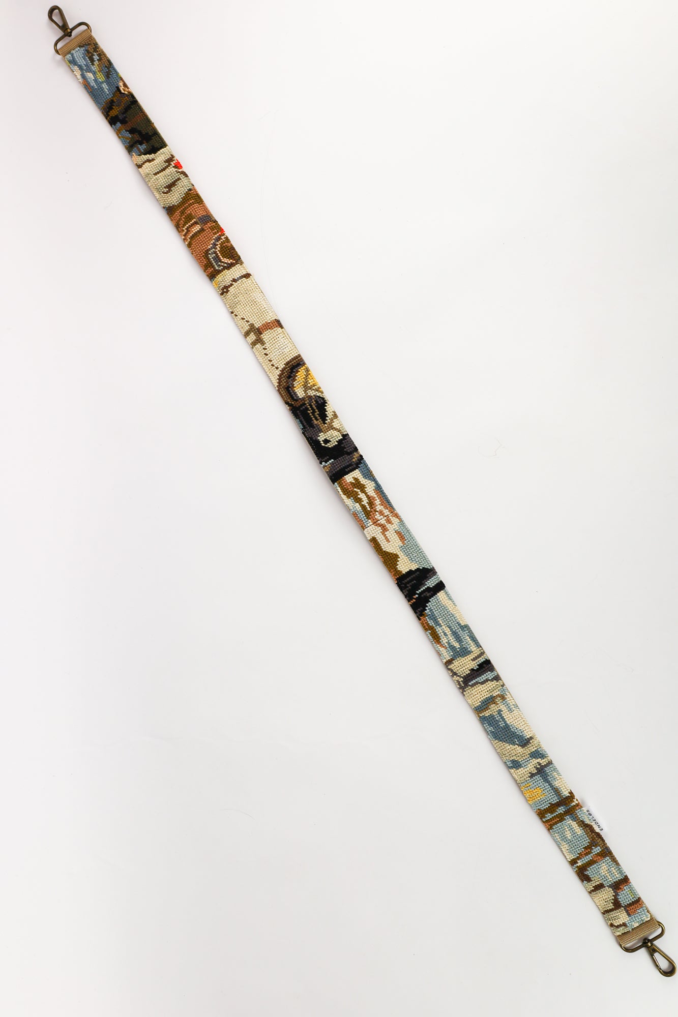 Close-up van de strap met geborduurd schilderij van drie paarden die hout verslepen, in een mix van blauw, bruin en rood.
