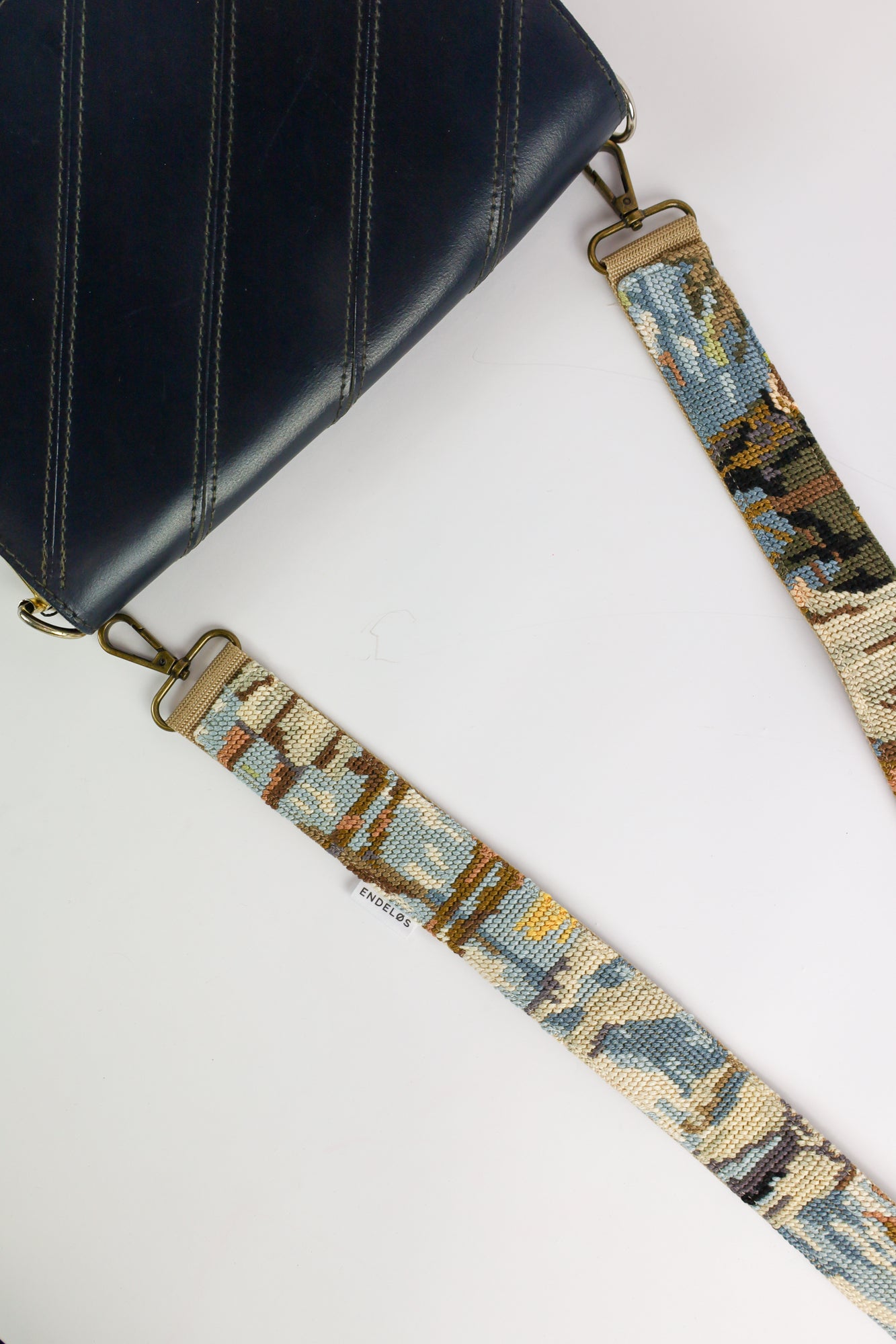 Duurzame handgemaakte strap met vintage geborduurd schilderij van paarden en boeren, in zachte kleuren van blauw, wit en bruin.