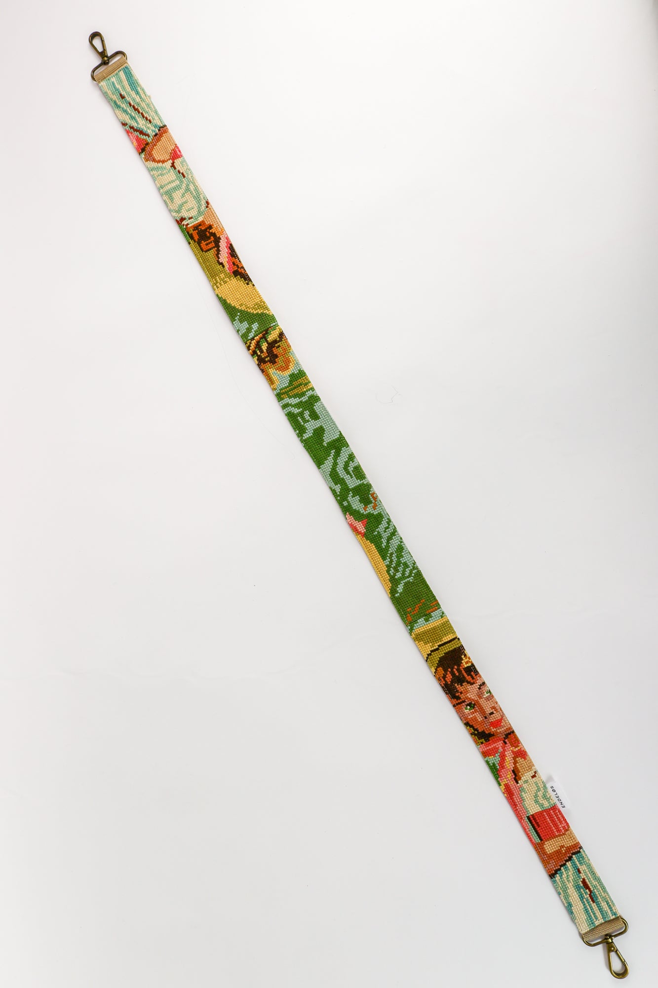 Close-up of the strap with embroidered painting of a girl with a hat, in lively pink, green, blue, and yellow shades.