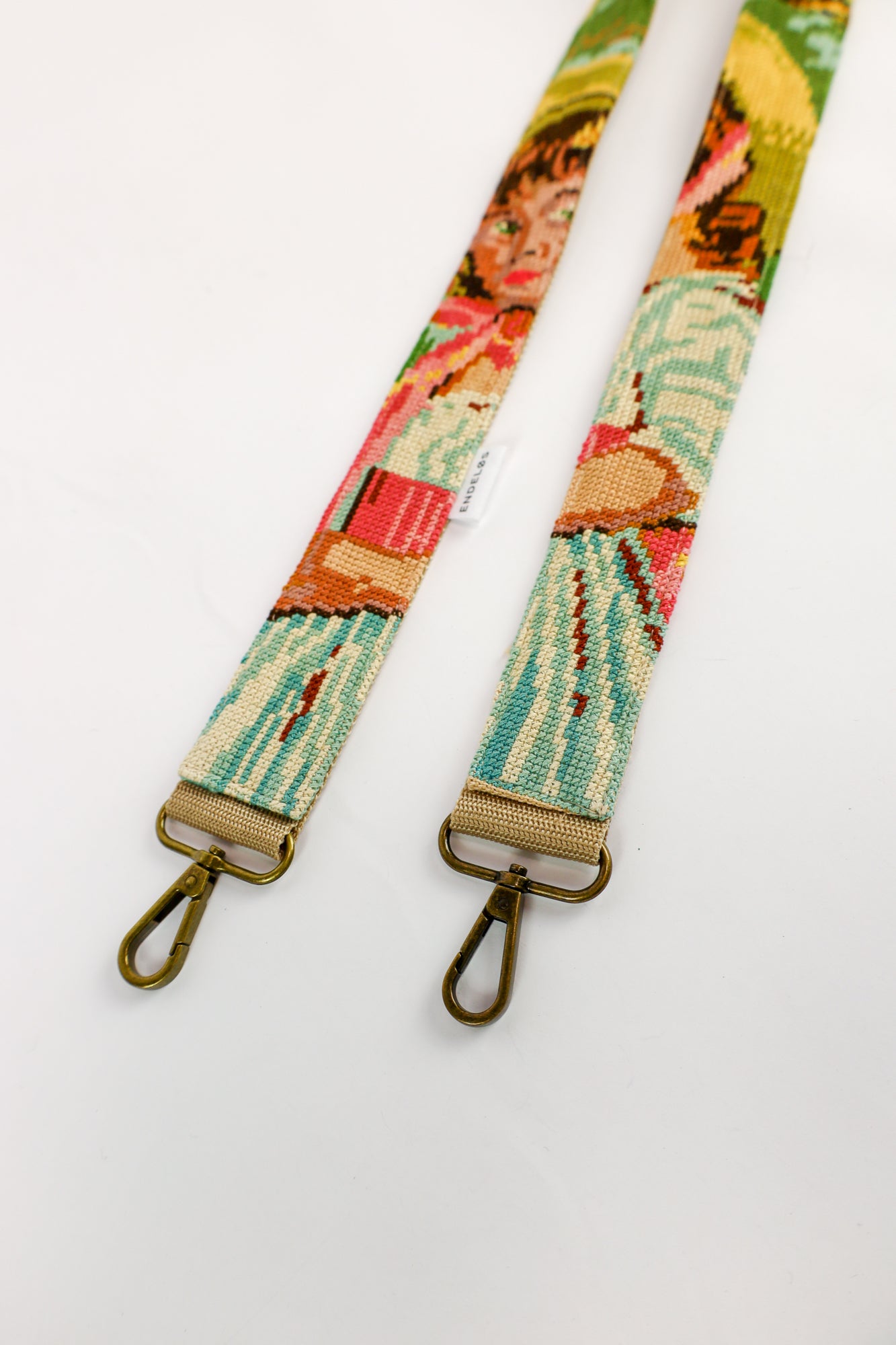 Duurzaam handgemaakt accessoire with an embroidered painting of a girl wearing a hat, perfect for your bag, phone, or camera.
