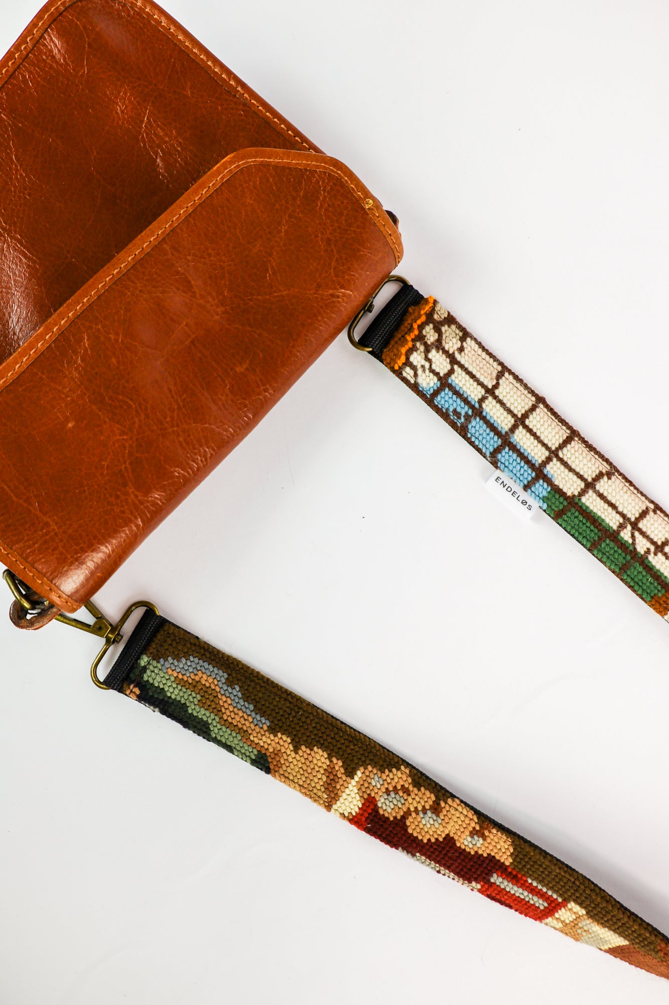 Strap gemaakt van een geborduurd schilderij van een drinkende man, met donkere tonen van groen, zwart en bruin voor een rijke uitstraling.