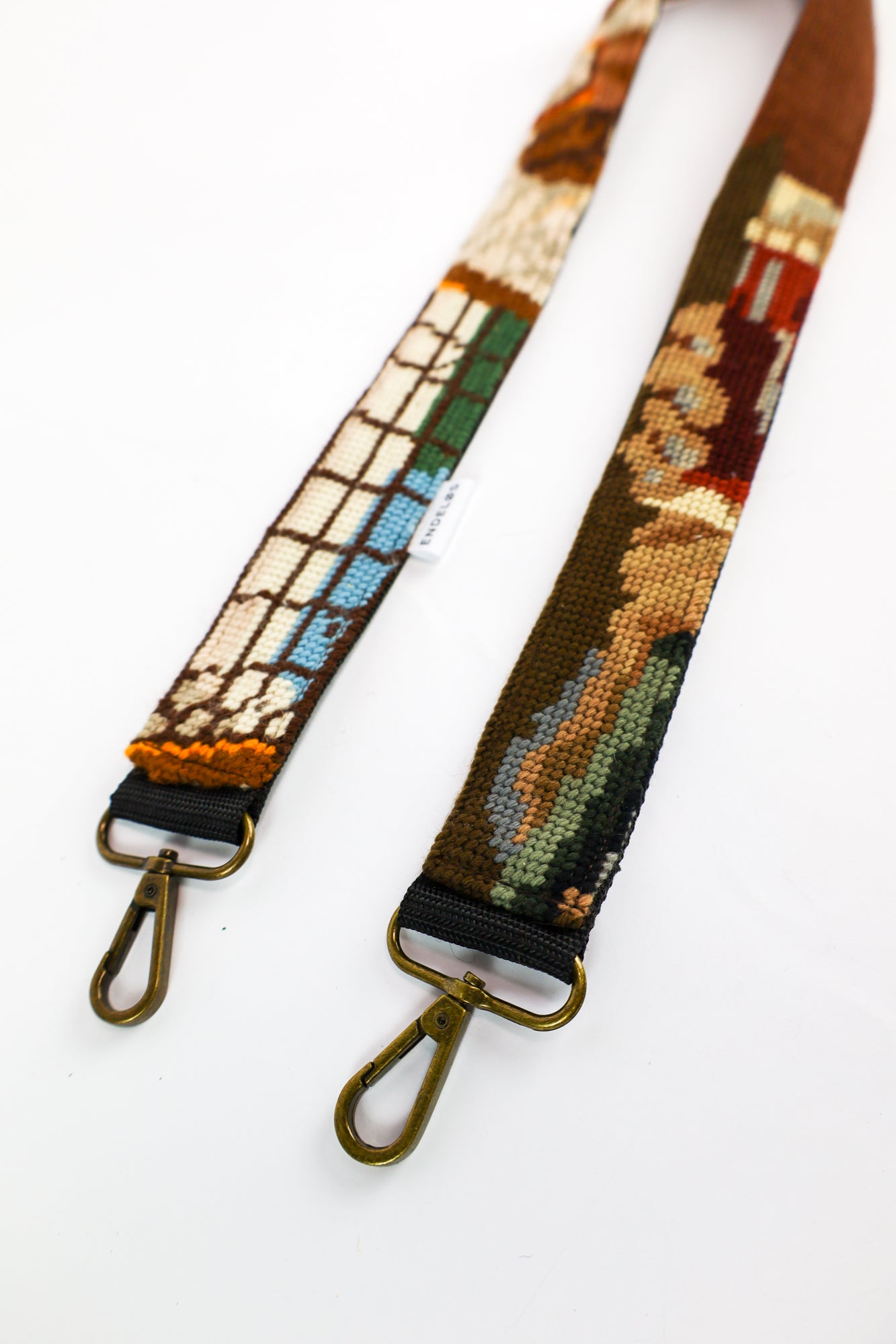 Close-up van een strap gemaakt van een donker geborduurd schilderij, met rijke kleuren als groen, zwart en bruin voor een tijdloze uitstraling.