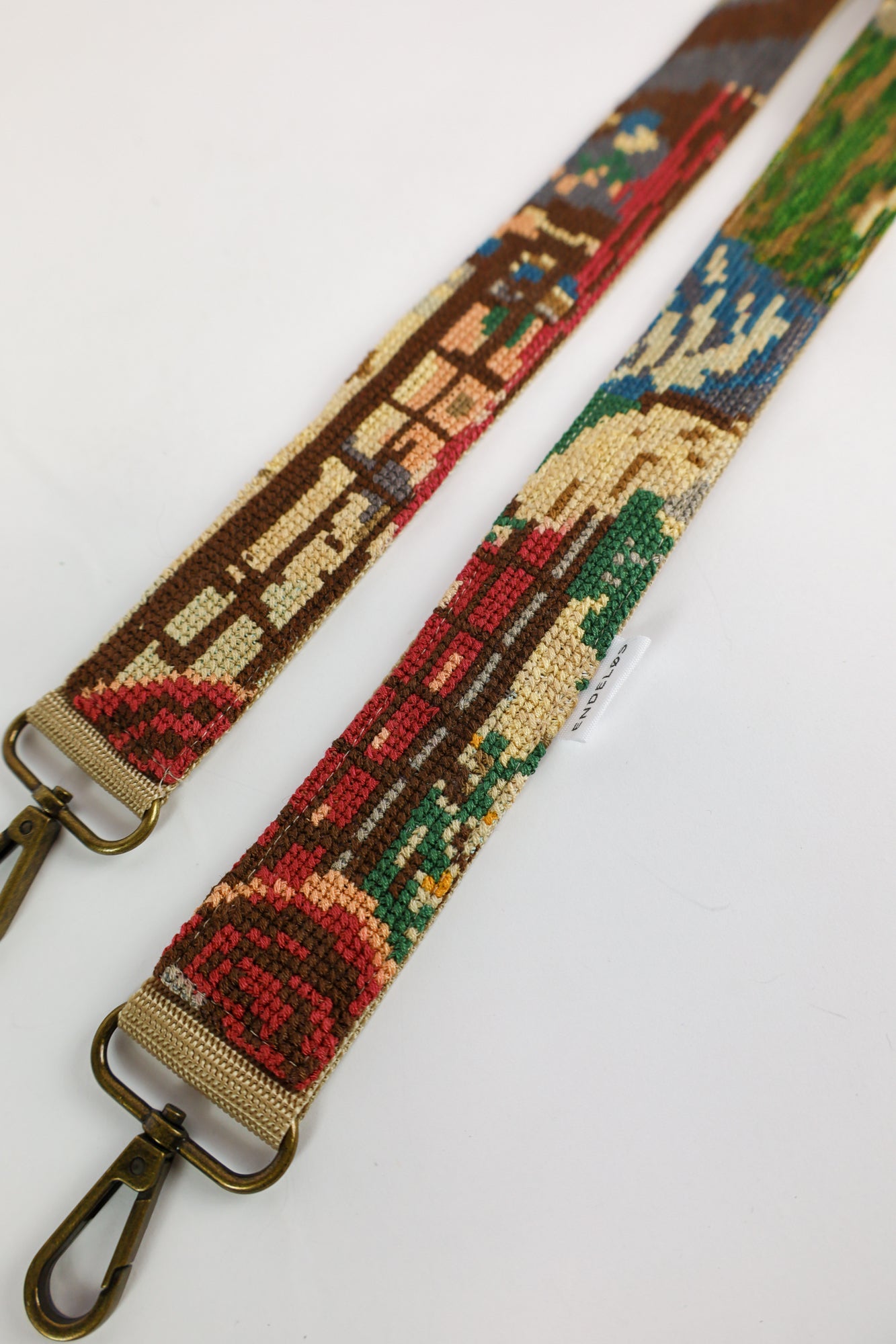 Duurzaam handgemaakt accessoire met geborduurd schilderij van Vrouw in het Venster in roze, groen en blauw, perfect voor tas, telefoon of camera.