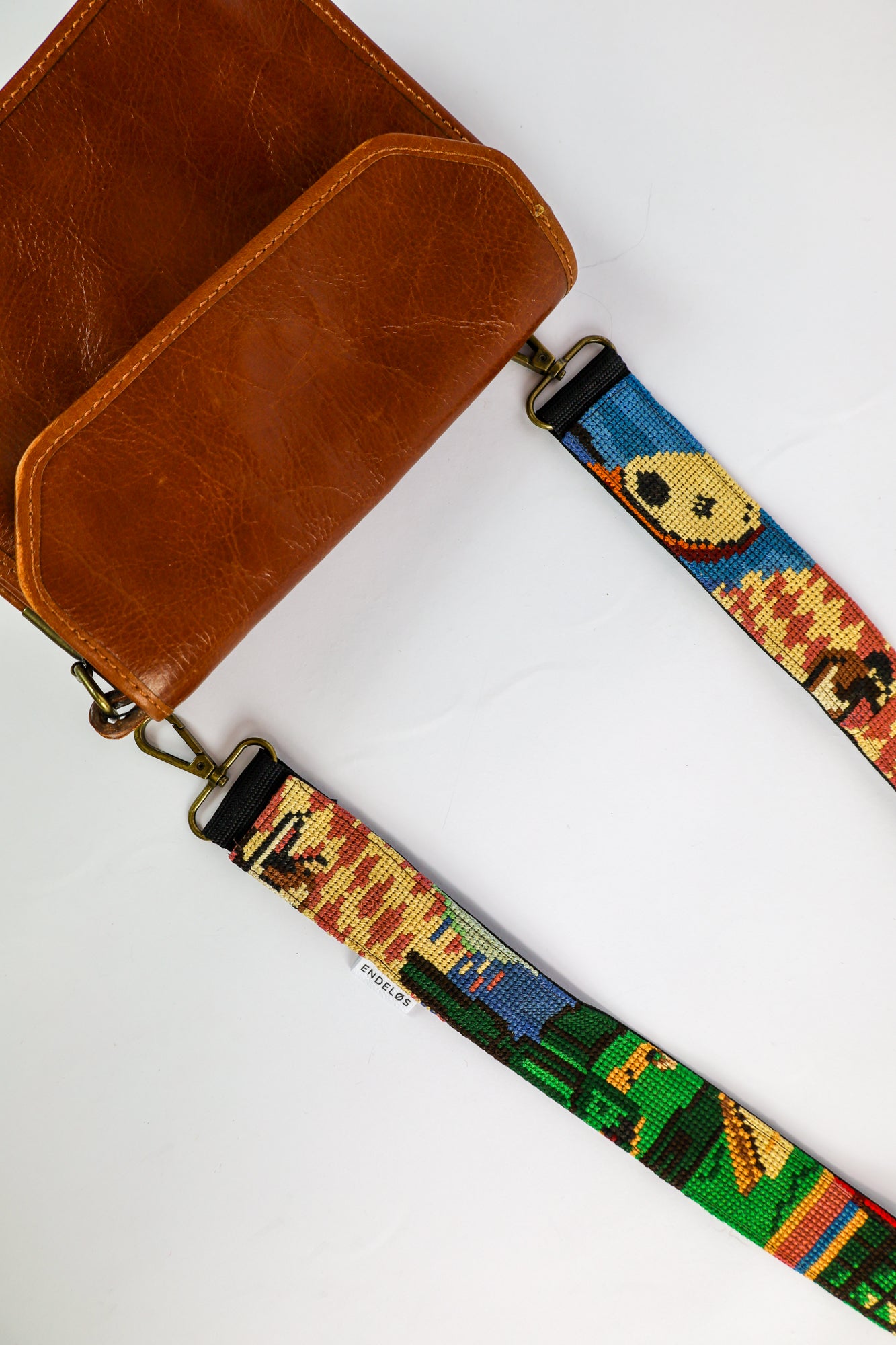 Handmade strap made from an embroidered artwork featuring vibrant colors, perfect for adding a unique touch to your bag, phone, or camera. Sustainable and stylish accessory.