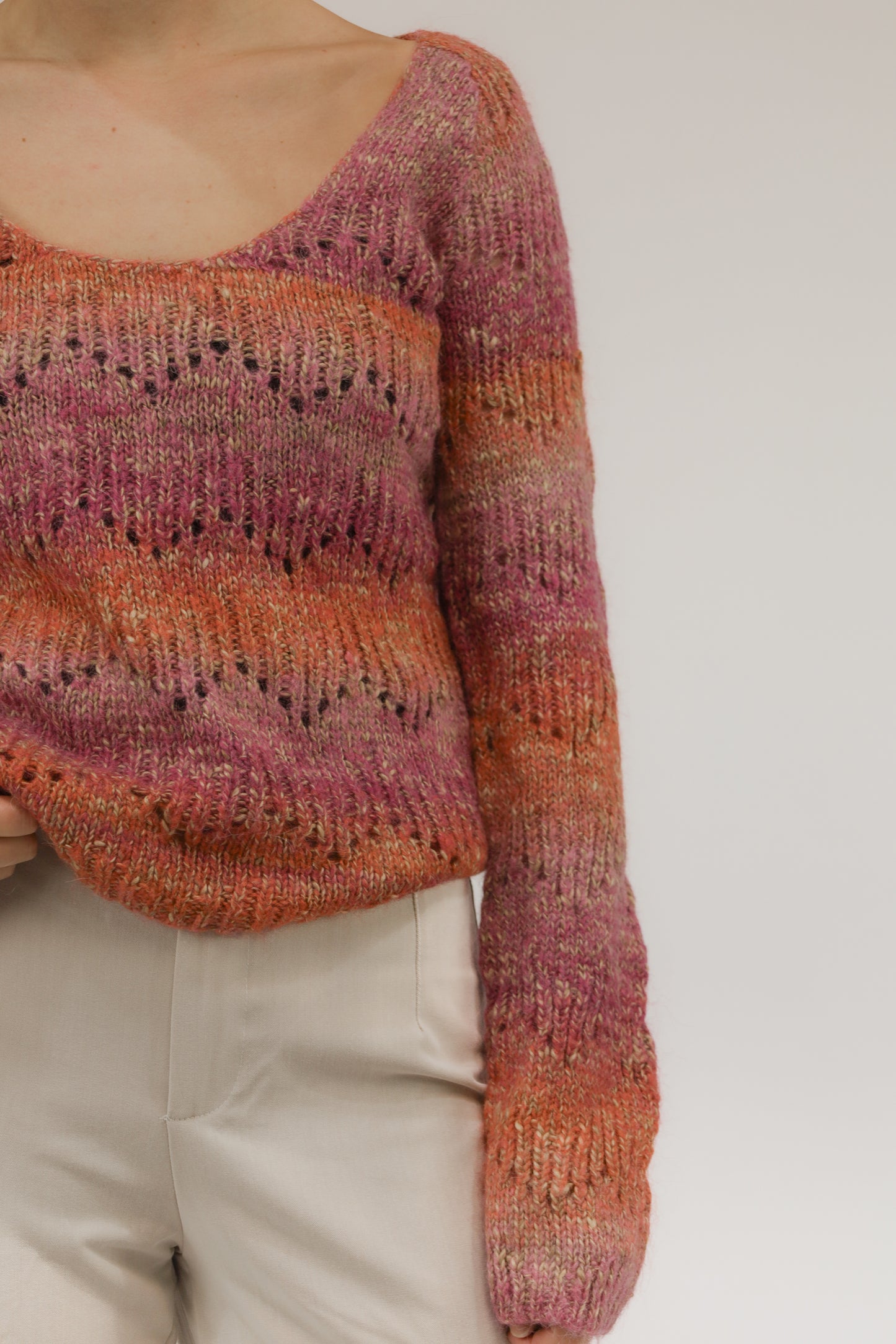 Close-up van model met fijngebreide trui – detail van open geweven textuur en zachte kleurencombinatie