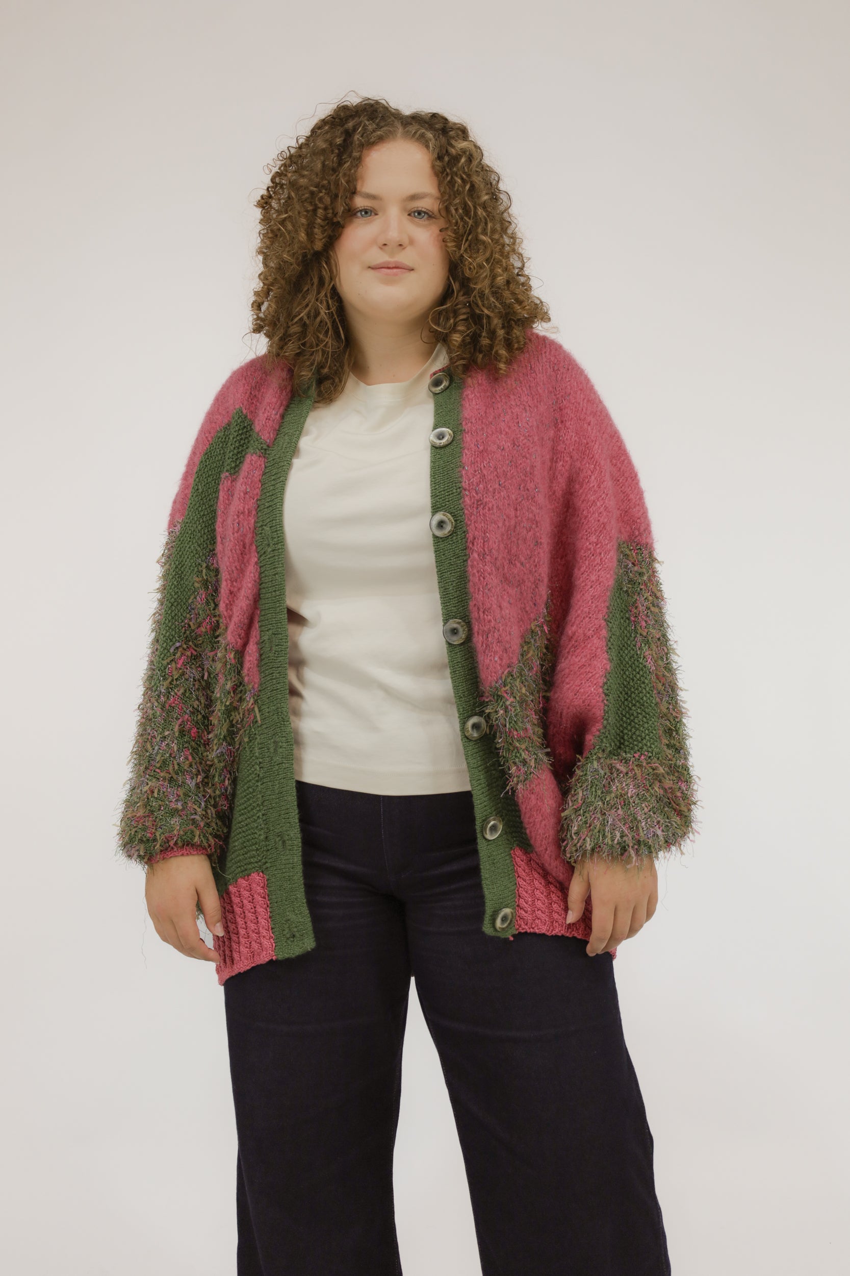 Model draagt oversized vintage vest in mosgroen met zuurstokroze accenten – vooraanzicht.