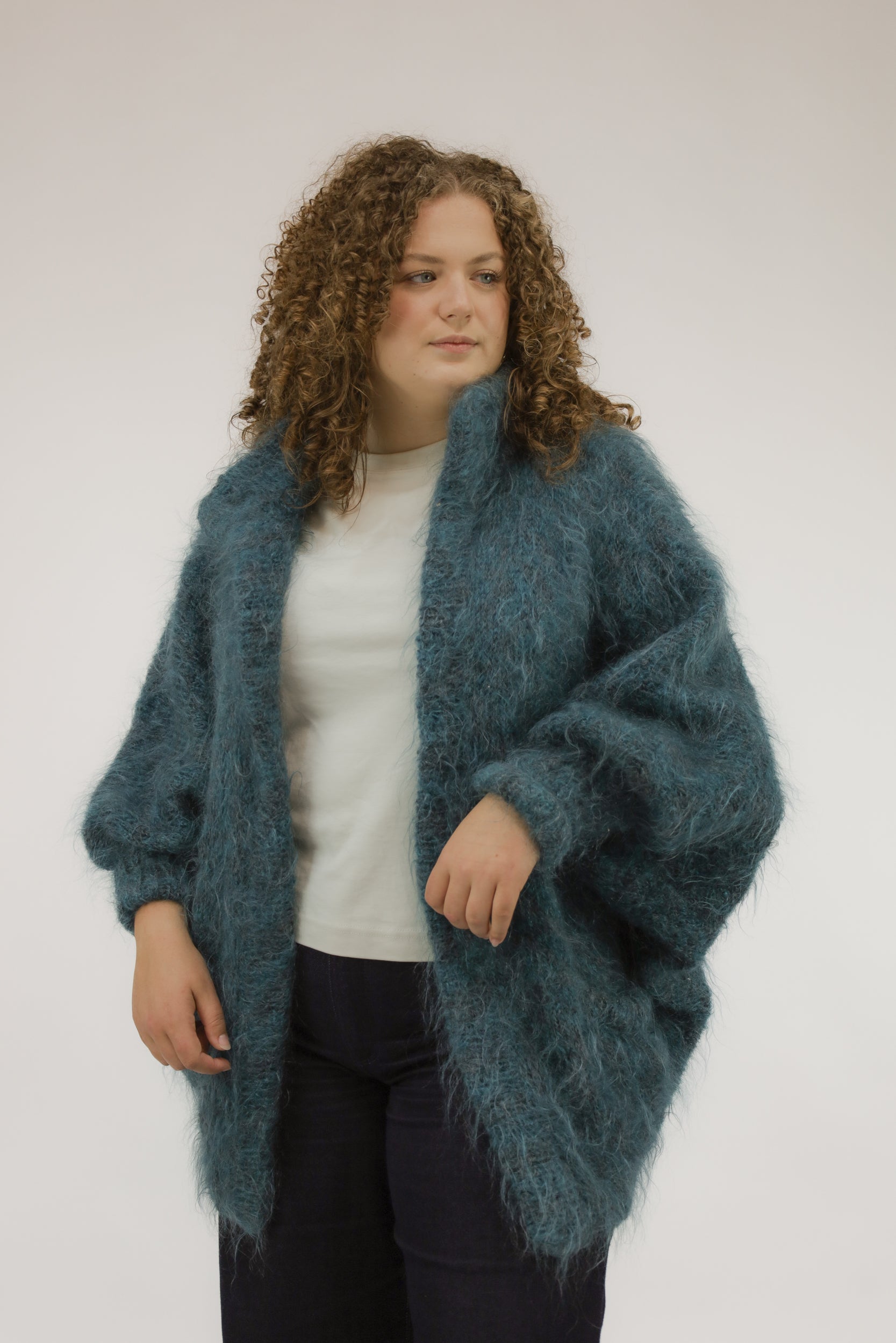 Model draagt oversized vintage knit in turkooisgroene kleur – vooraanzicht.
