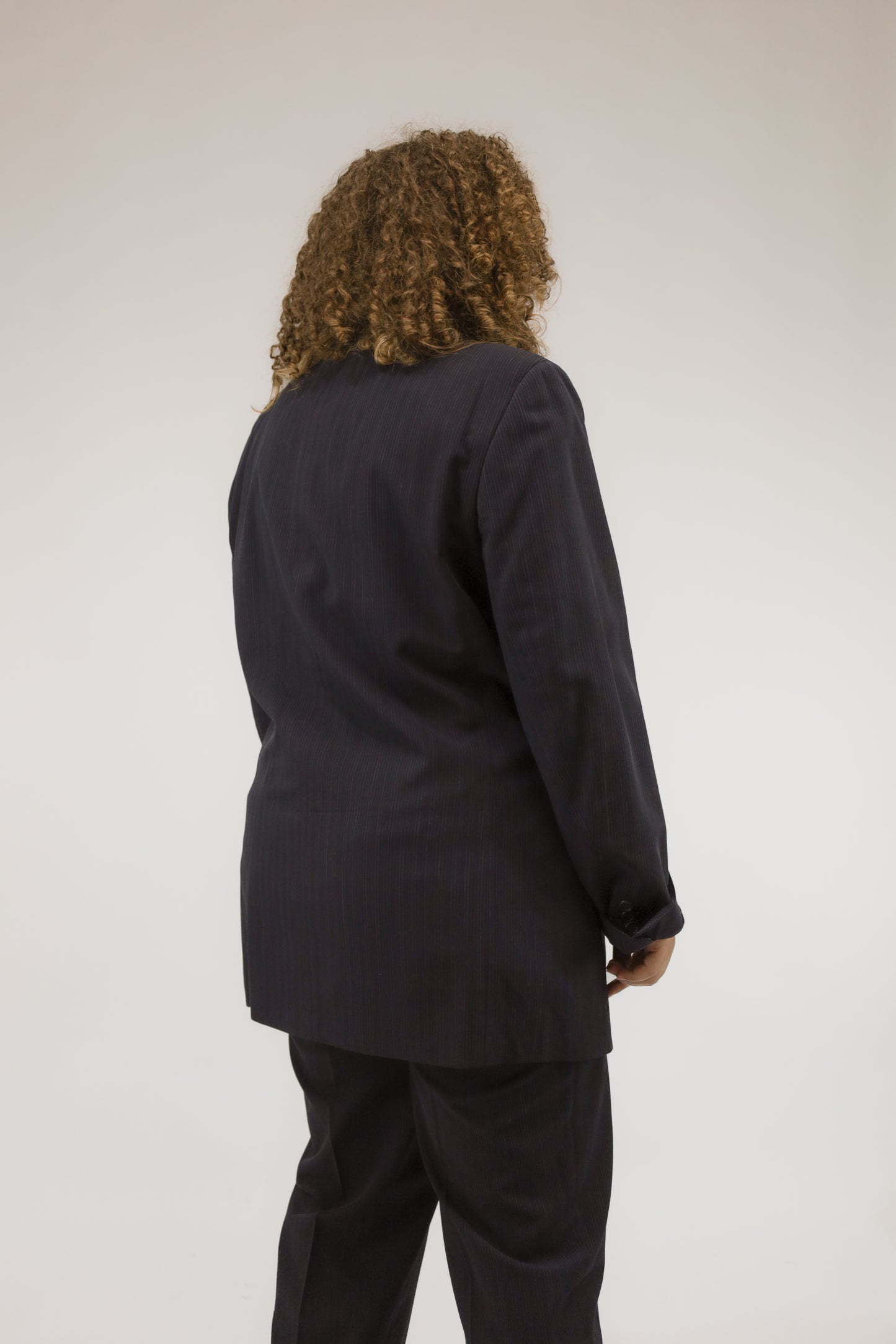 Detailopname van donkerblauw vintage pak, close-up van stof en knopen.