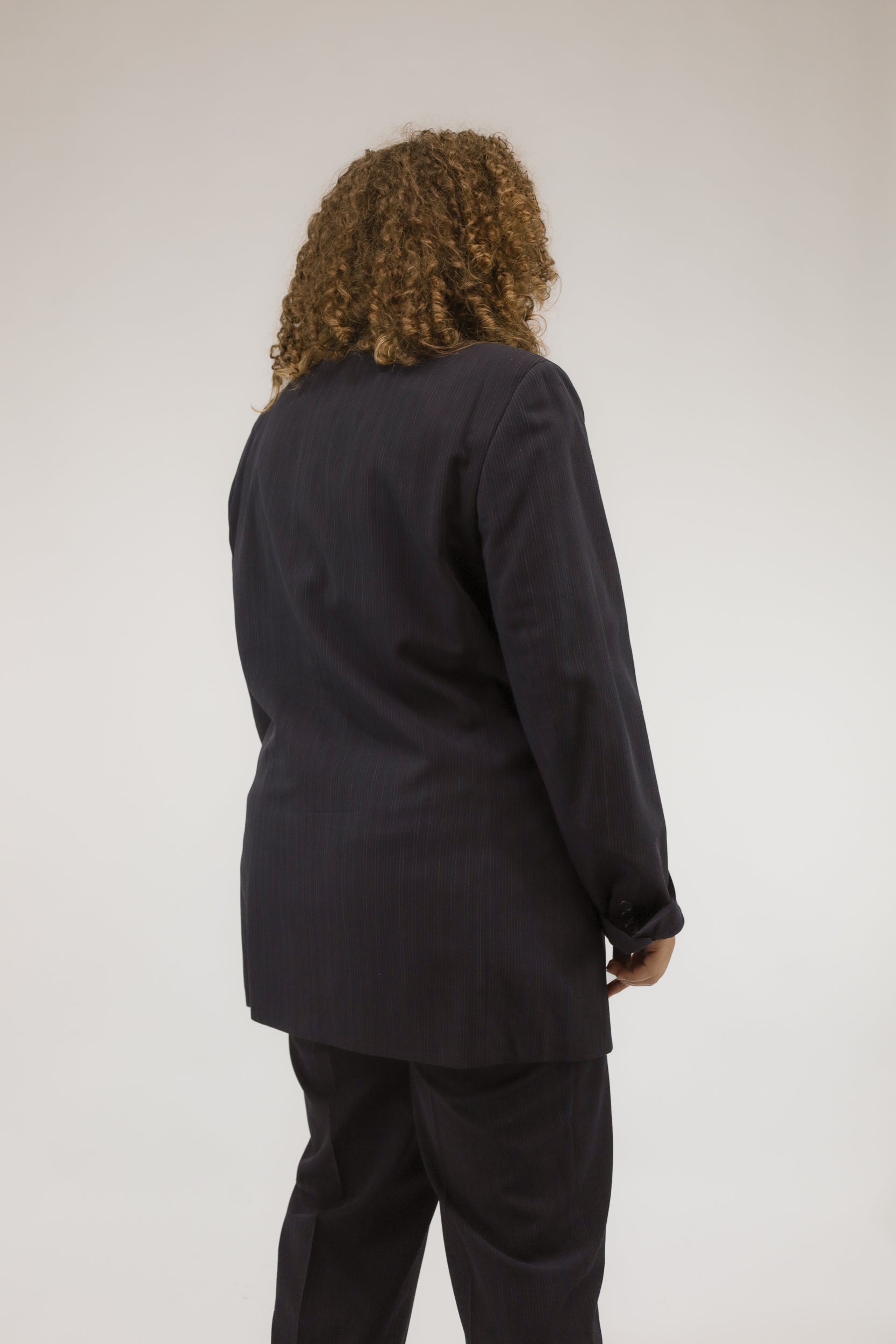 Detailopname van donkerblauw vintage pak, close-up van stof en knopen.