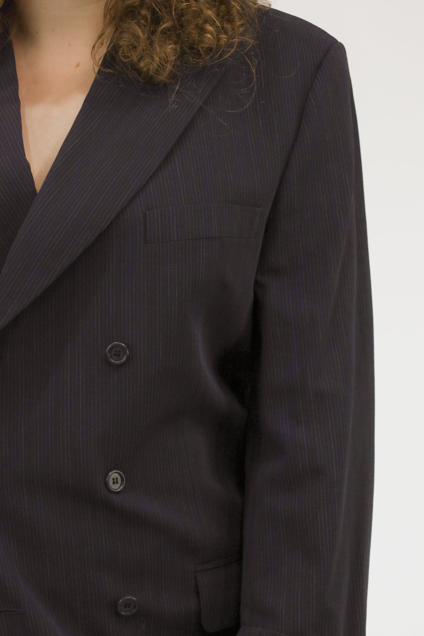 Detailopname van donkerblauw vintage pak, close-up van stof en knopen.