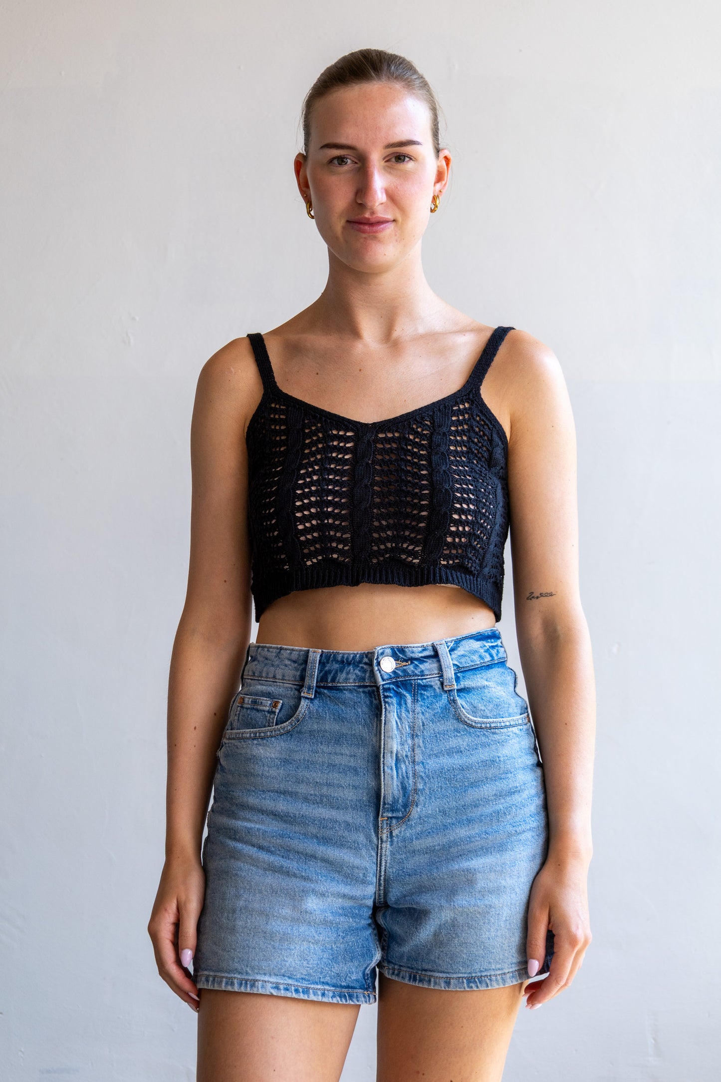 Vintage zwarte open gebreide cropped top met lichte V-hals en doorschijnende structuur.