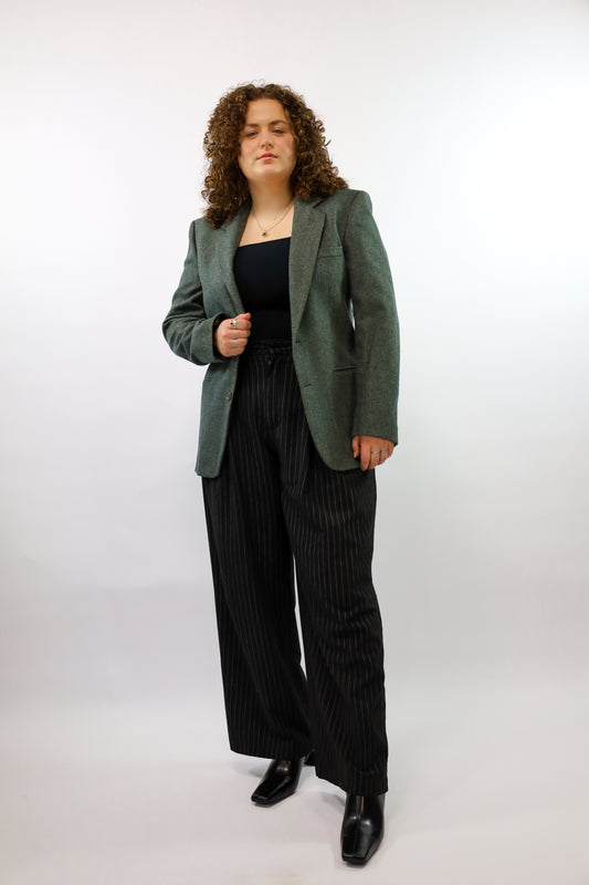 (EN) Full view of a tailored vintage blazer in melange green color.
(NL) Volledig beeld van een licht getailleerde vintage blazer in melange groene kleur.
