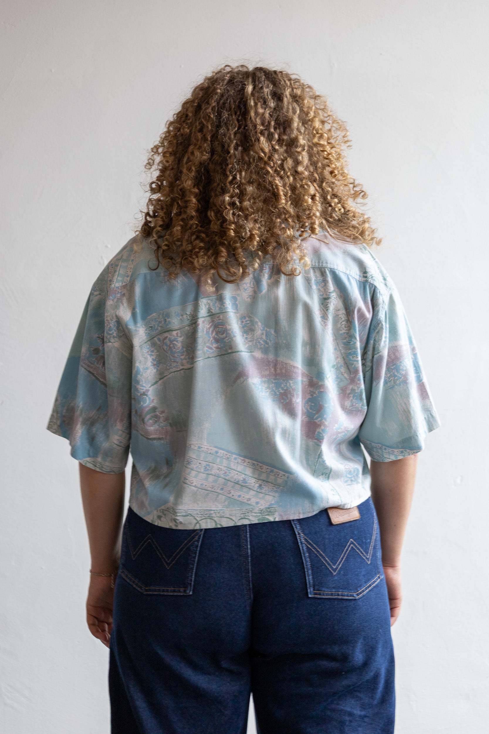 Achterzijde van de korte vintage blouse met doorlopende fantasy all-over print.