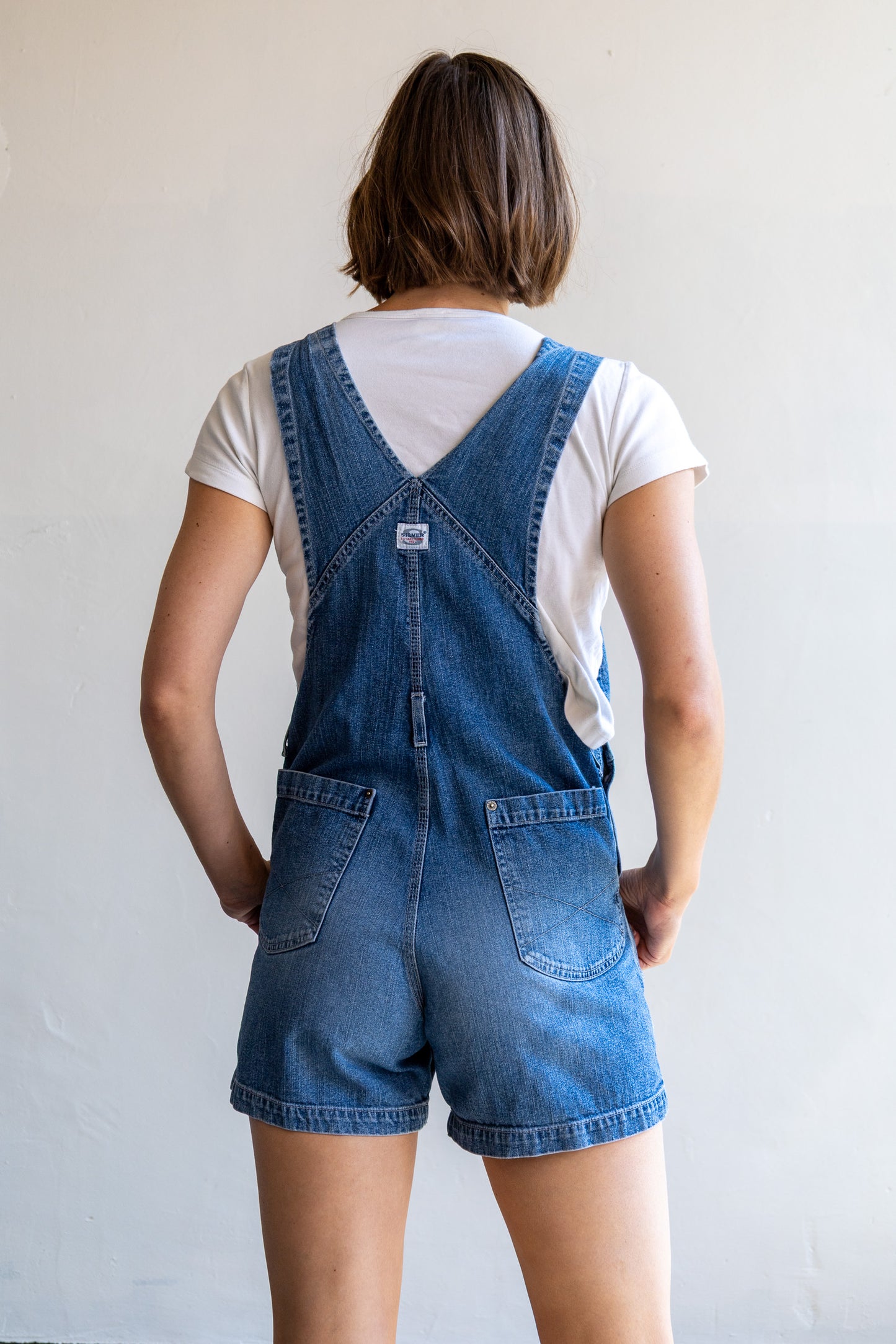 Achterzijde van de vintage denim jumpsuit met korte broekspijpen en tuinbroekmodel.