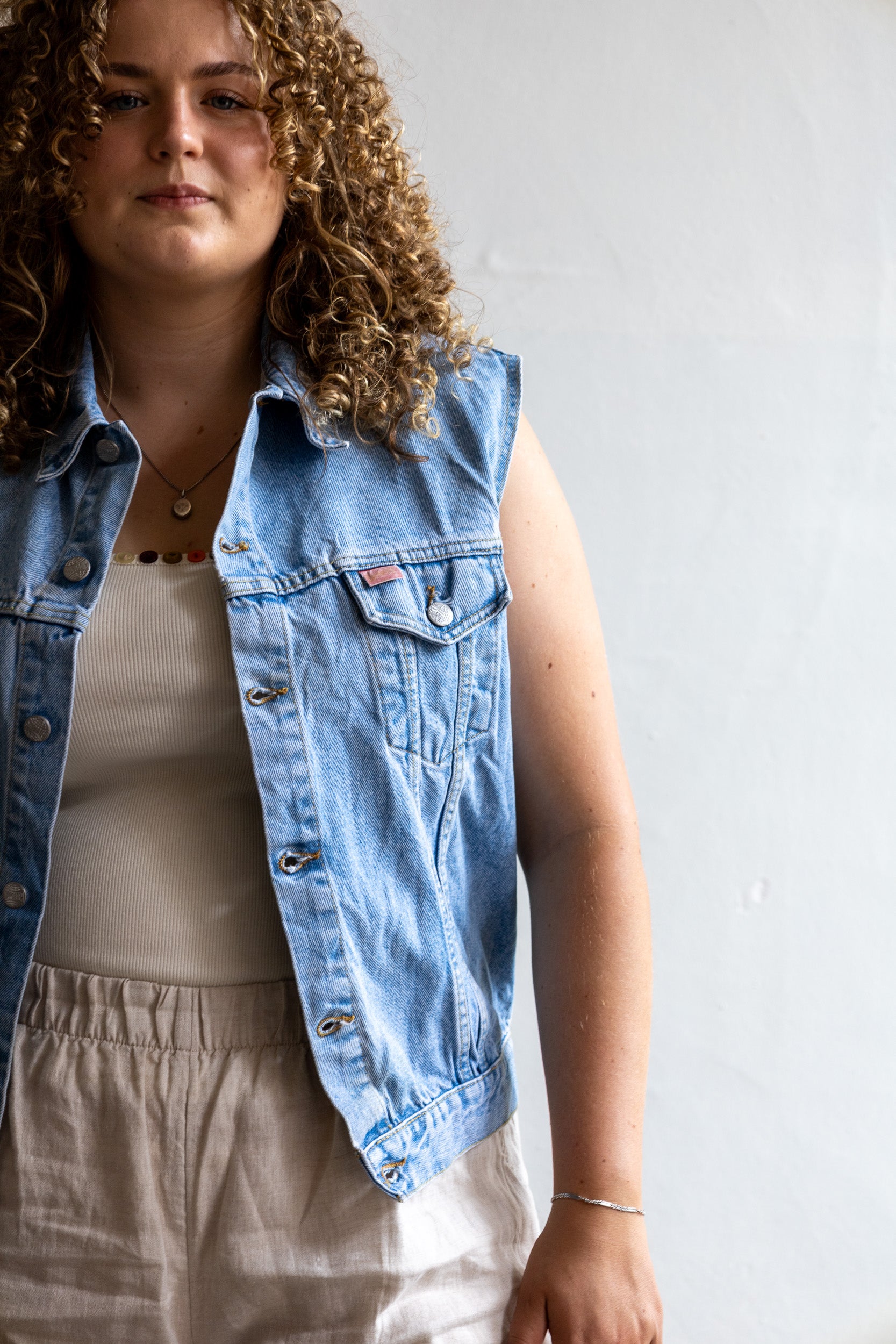 Detail van het vintage denim gilet met lichte wassing en klassieke denim structuur.