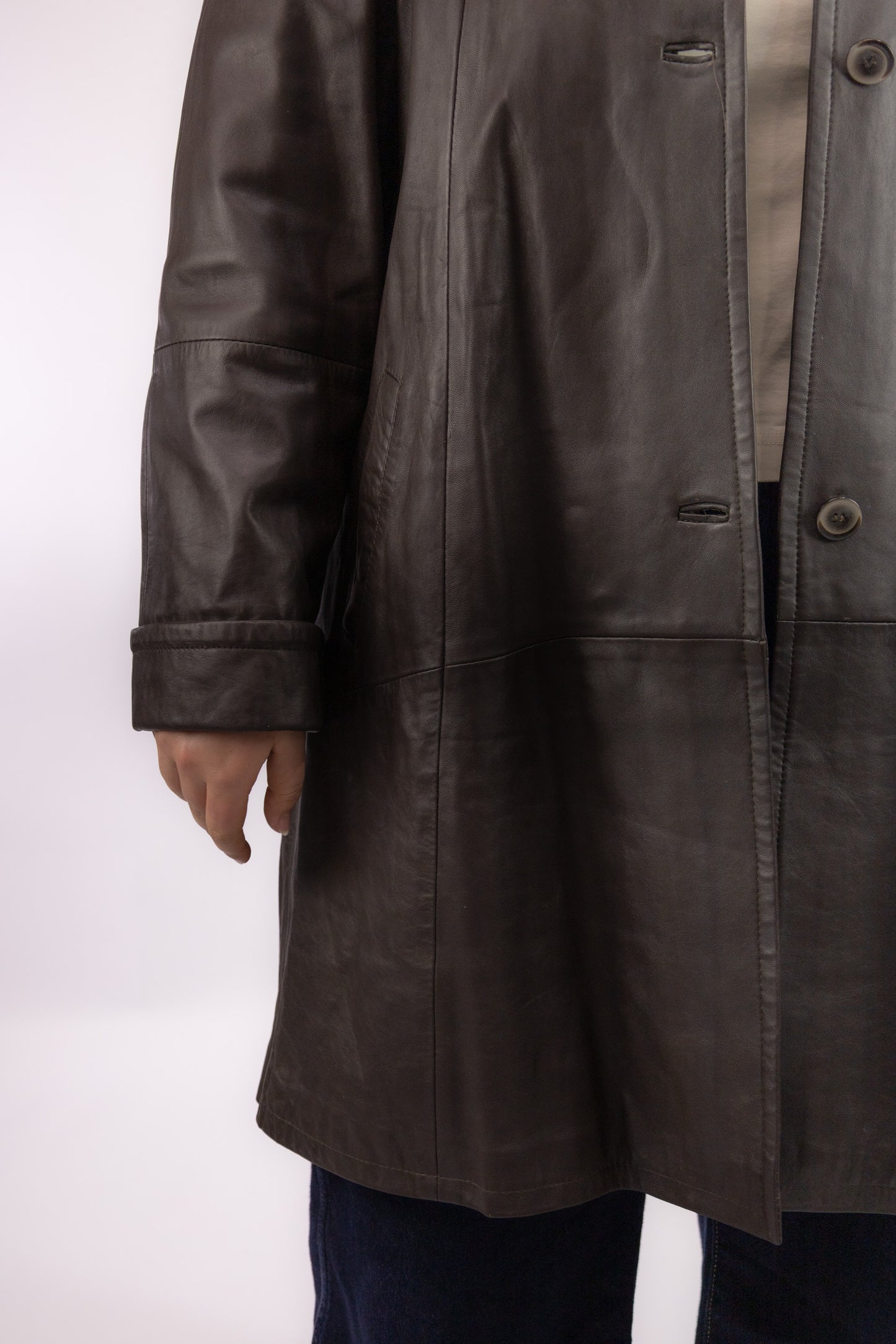 Detail van donkerbruin leer en uitneembare fluffy wintervoering in vintage mantel