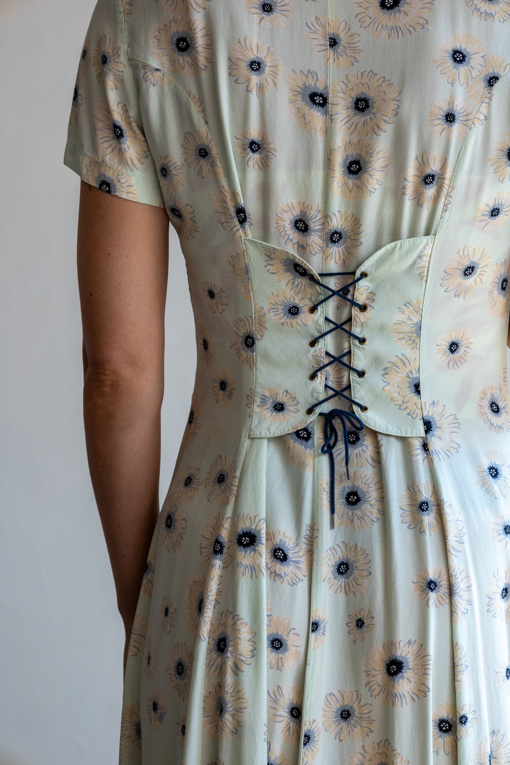 Detail van de vintage bloemenjurk met mintgroene stof en verfijnde bloemenprint.