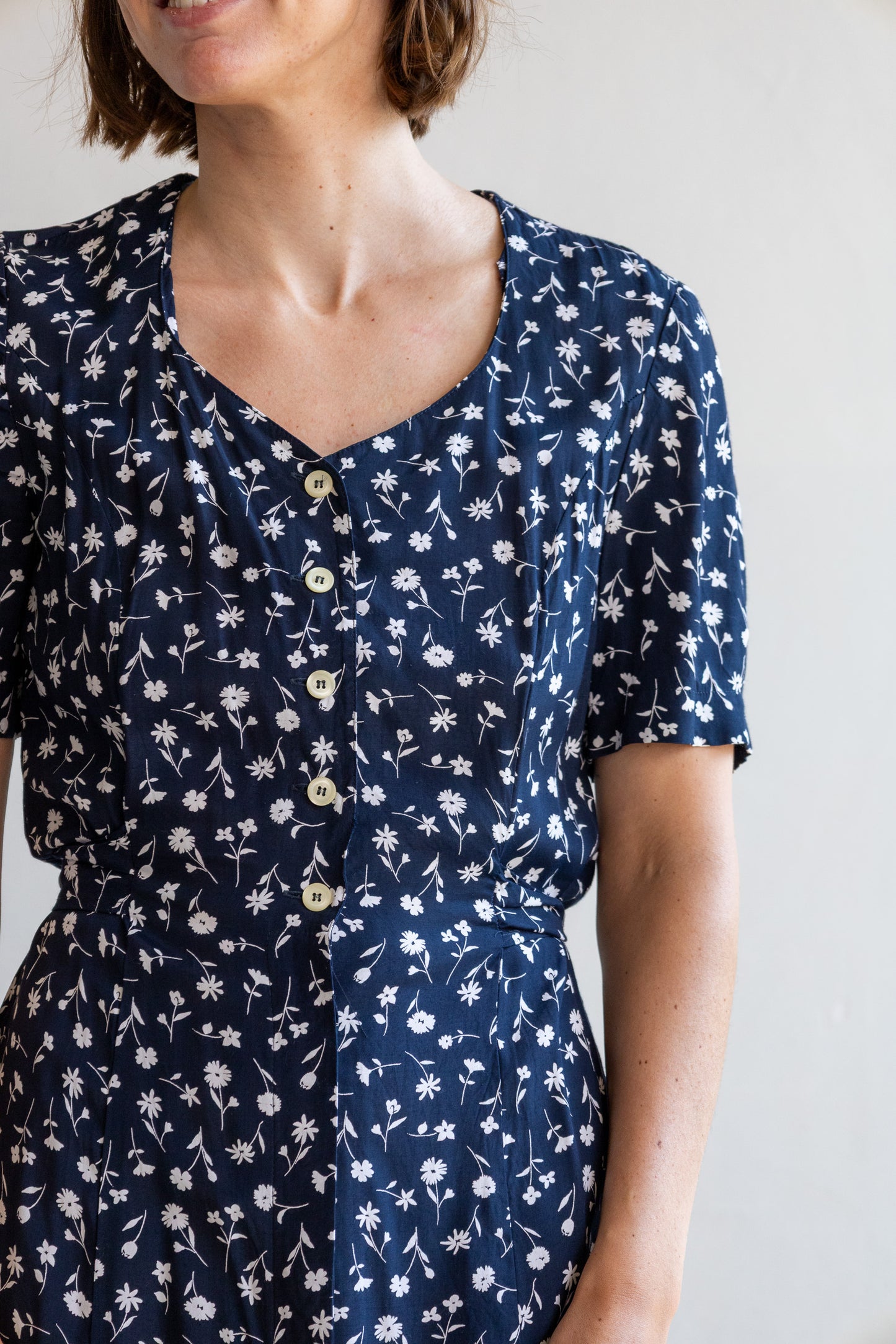 Detail van de vintage viscose jurk met bloemenprint, knoopsluiting en soepelvallende stof.