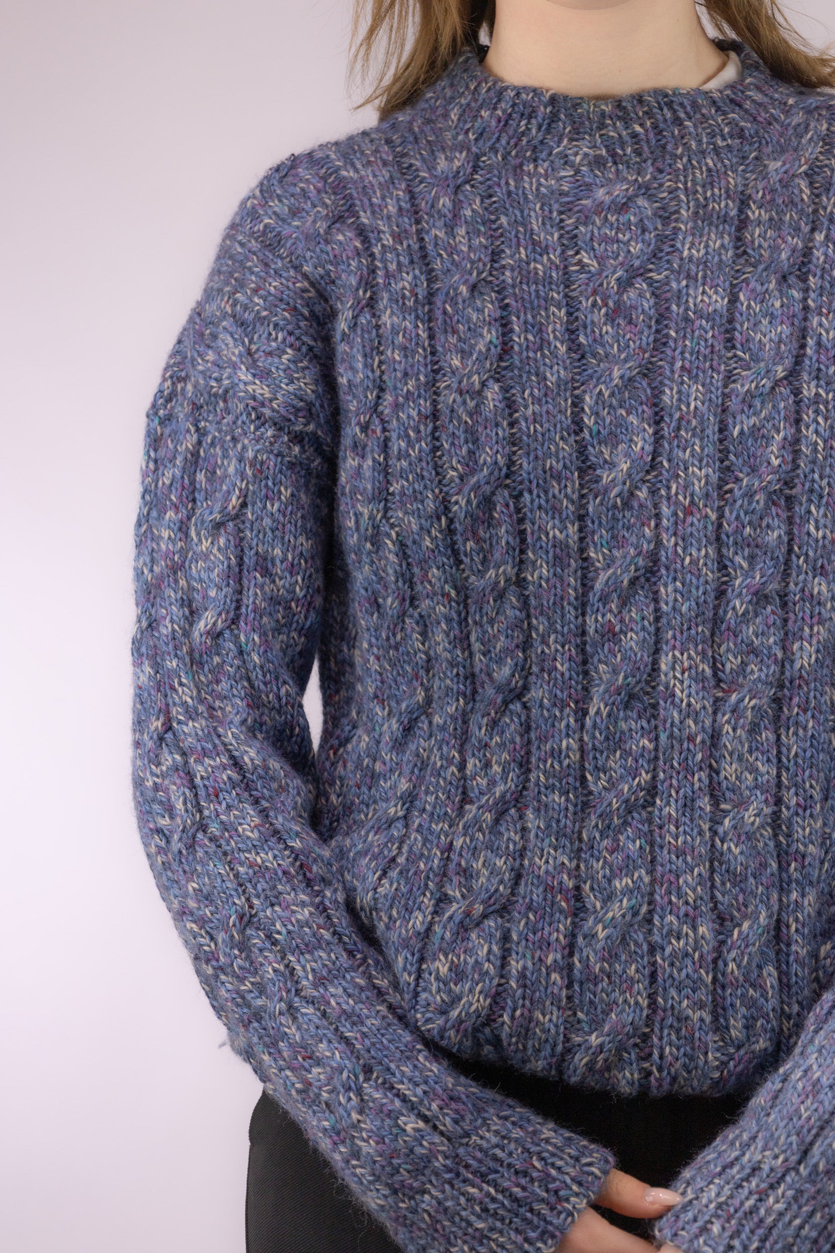 Detail van smalle ingebreide kabels in melange blauwe vintage trui