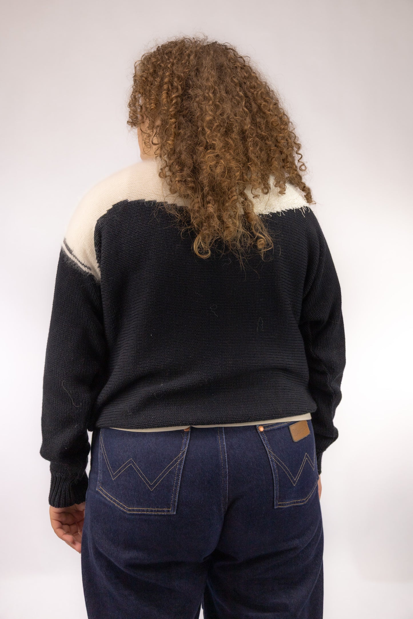 Achteraanzicht van zwarte vintage trui met witte accenten – achteraanzicht