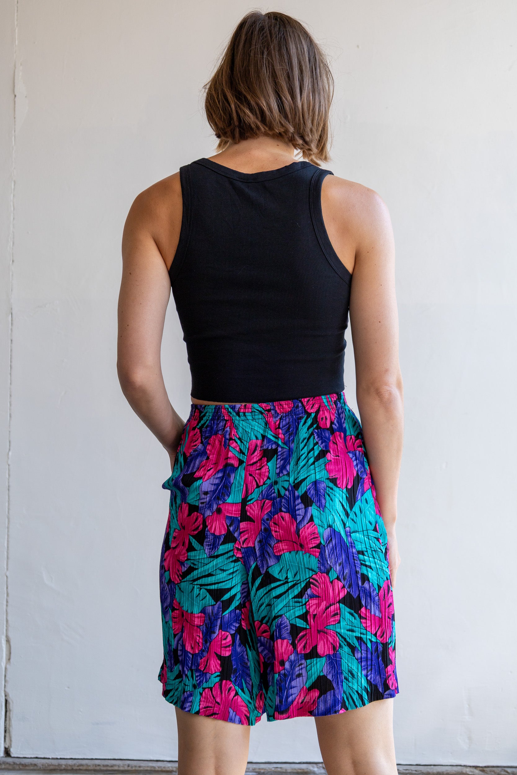 Achterzijde van de vintage plissé short met wijde pasvorm en kleurrijke Hawai print.