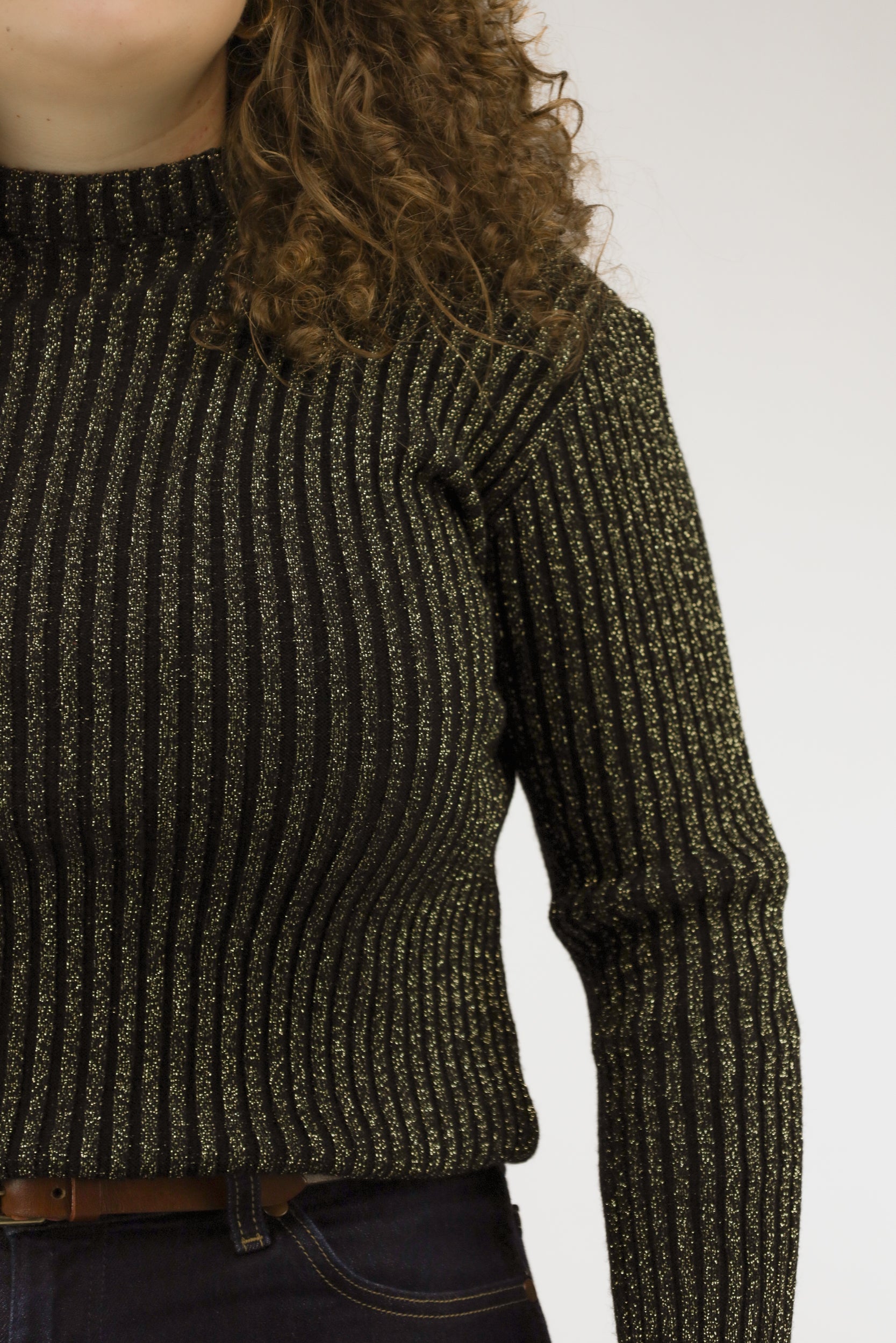 Detail van het breisel met gouden glitterdraad in zwarte vintage trui