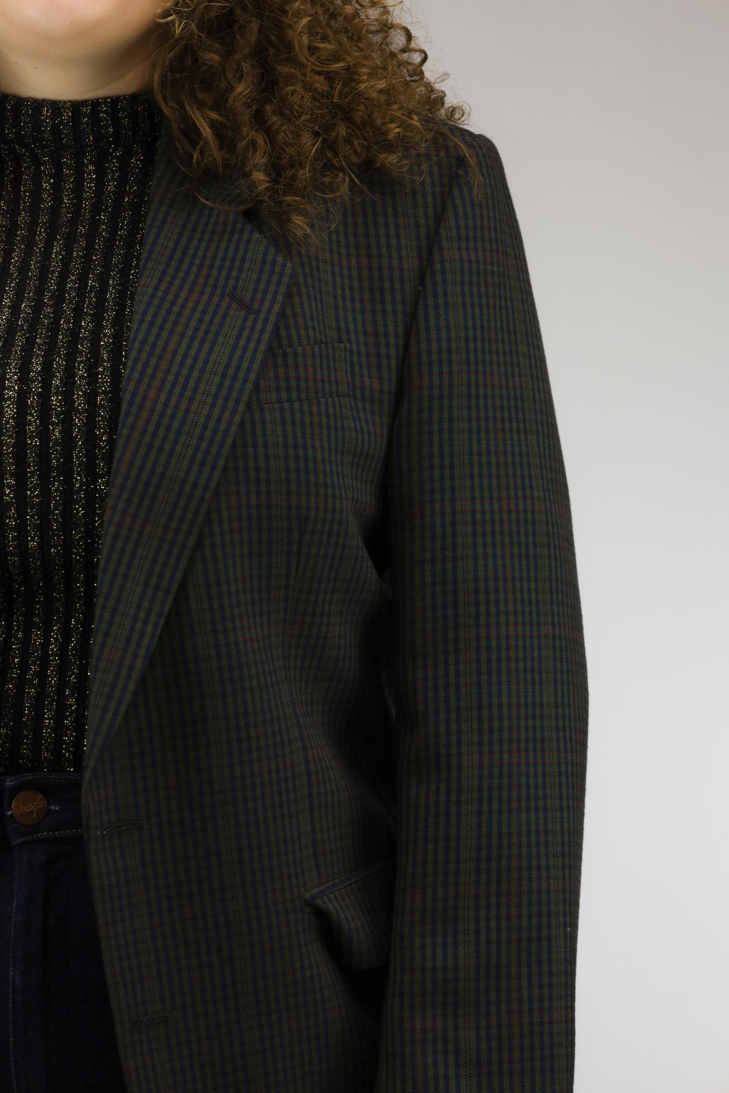 Detail van check print en paspelzak met klemzak van vintage blazer