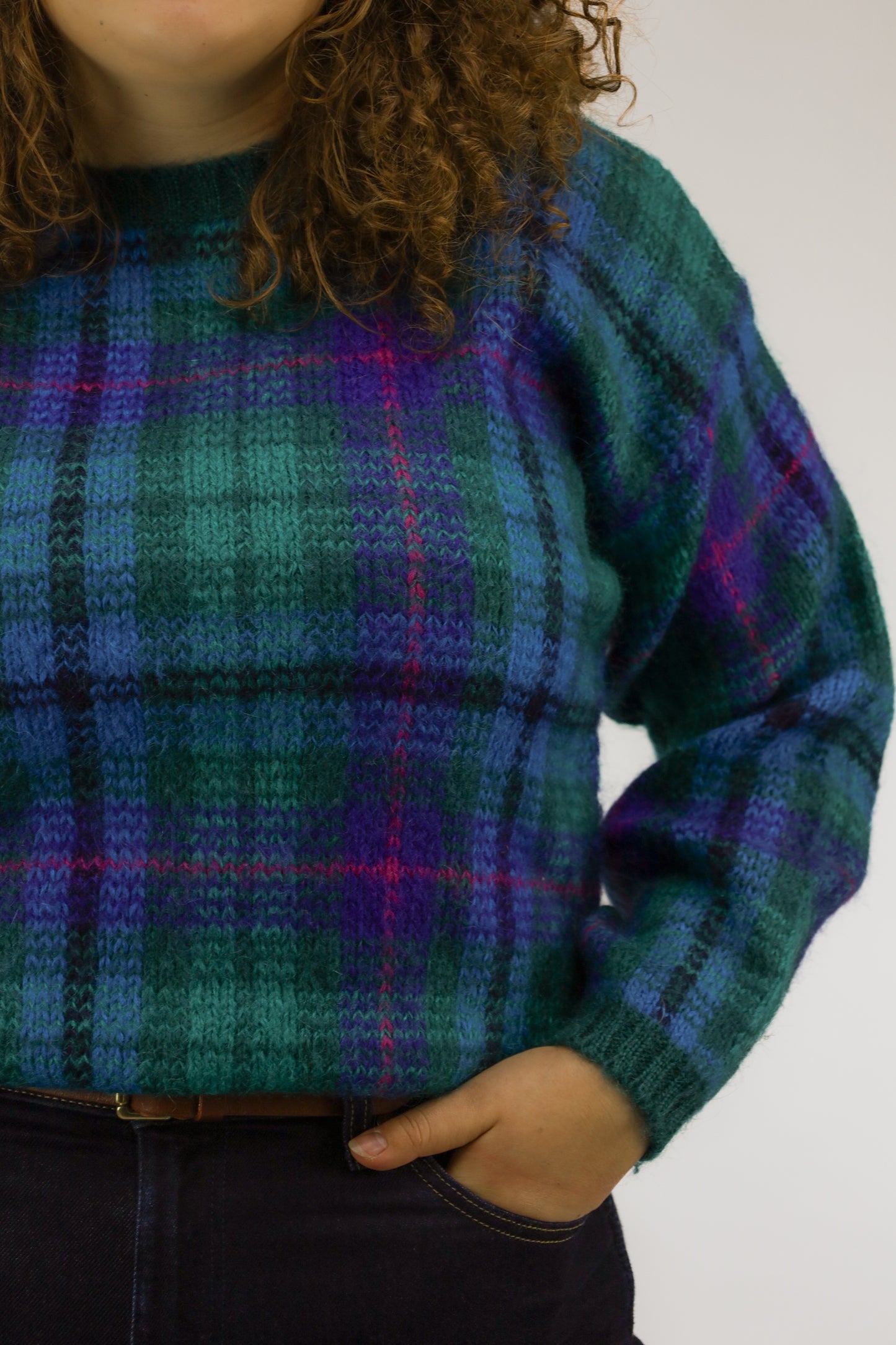 Detail van de fijngebreide check print in groene, paarse en blauwe tinten