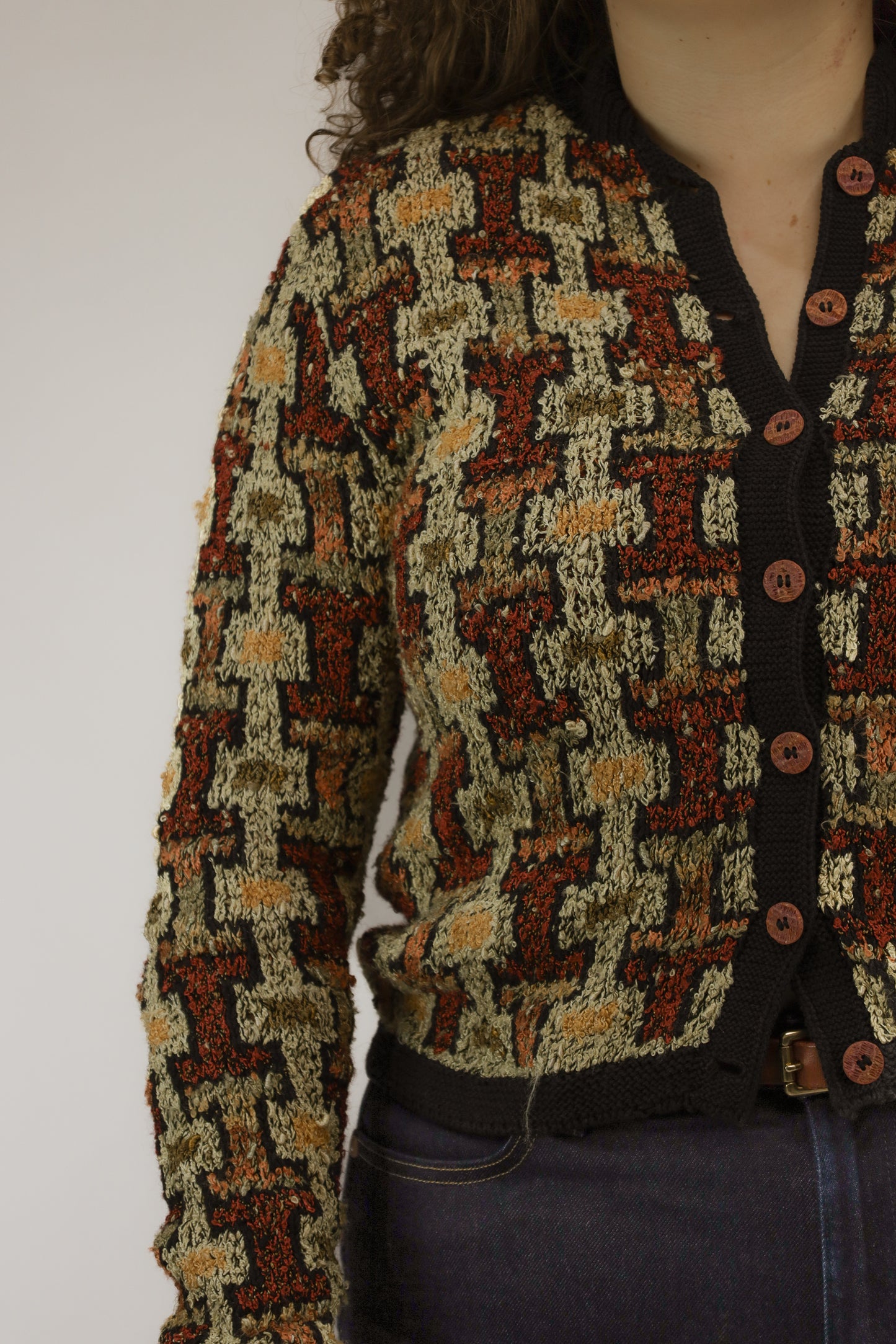 Detail van het geometrische patroon en zwart afgezet band van handgebreid vintage vest