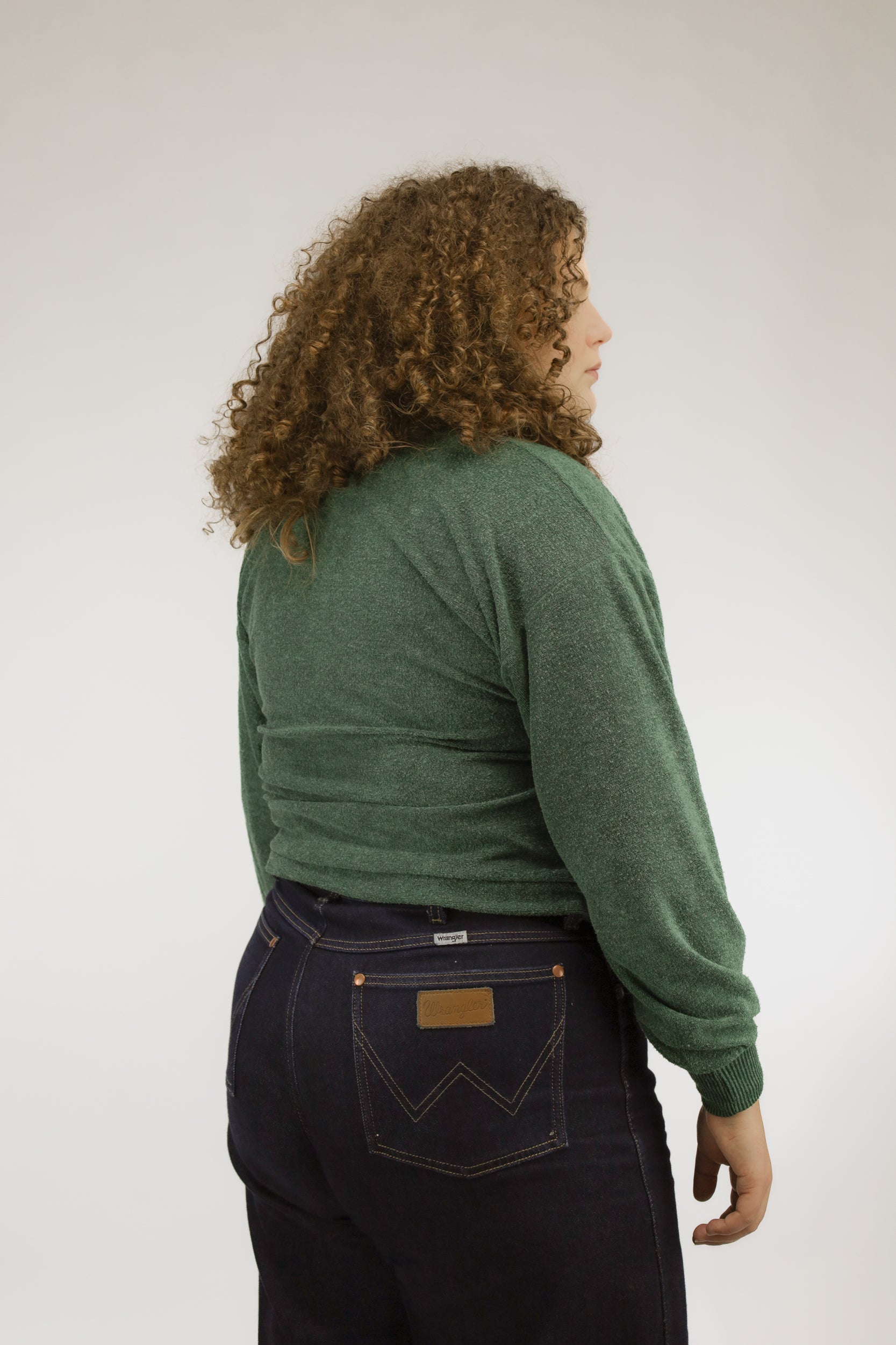 Achteraanzicht van groen zacht gebreid vintage vest met lichte pofmouwen