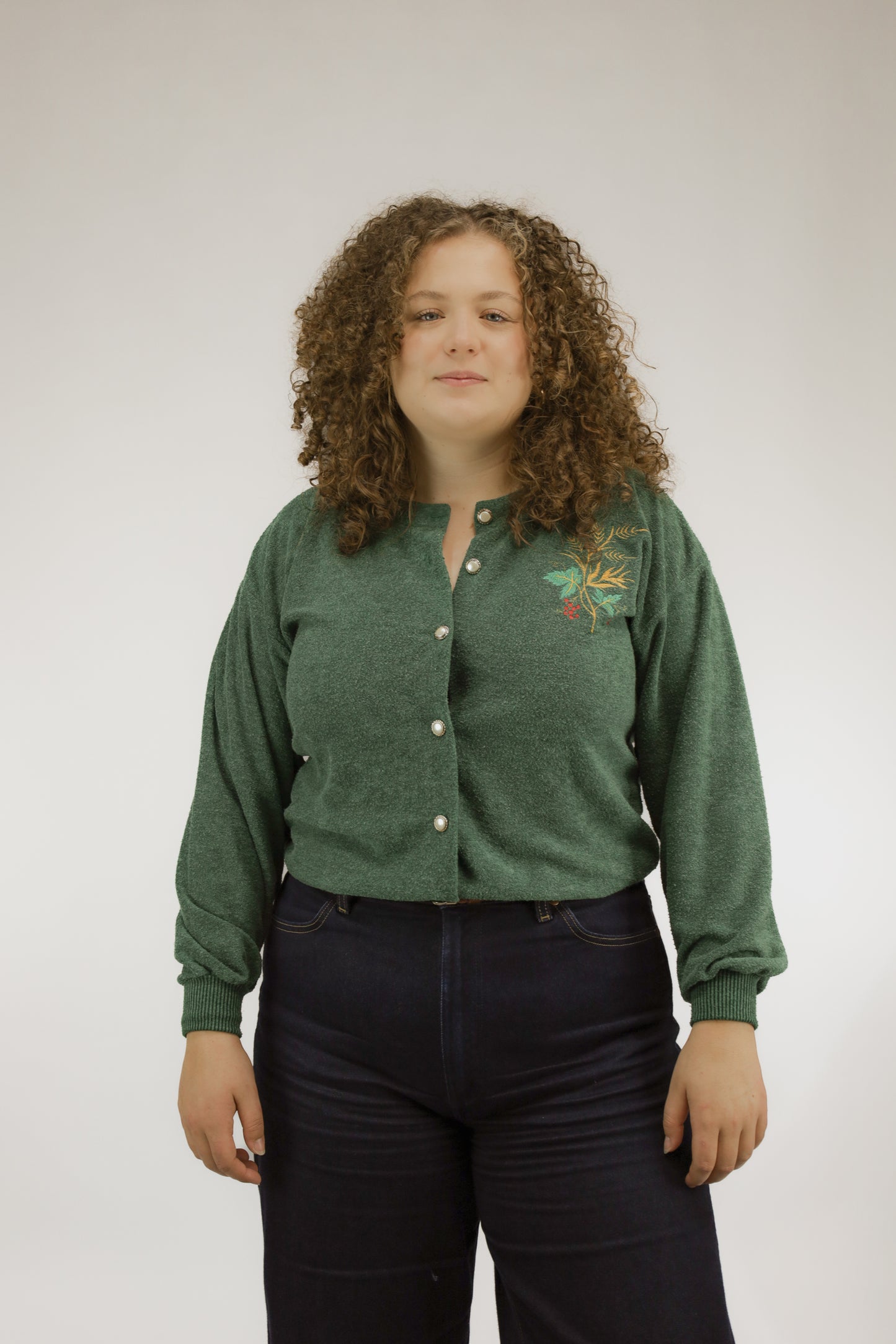 Groen zacht gebreid vintage vest met subtiel kerstborduursel en parelknopen, vooraanzicht