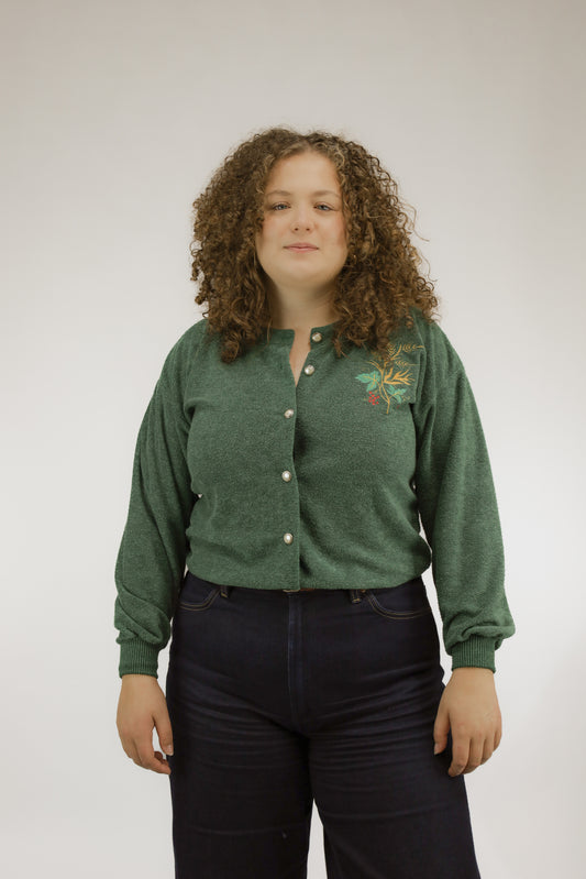 Groen zacht gebreid vintage vest met subtiel kerstborduursel en parelknopen, vooraanzicht