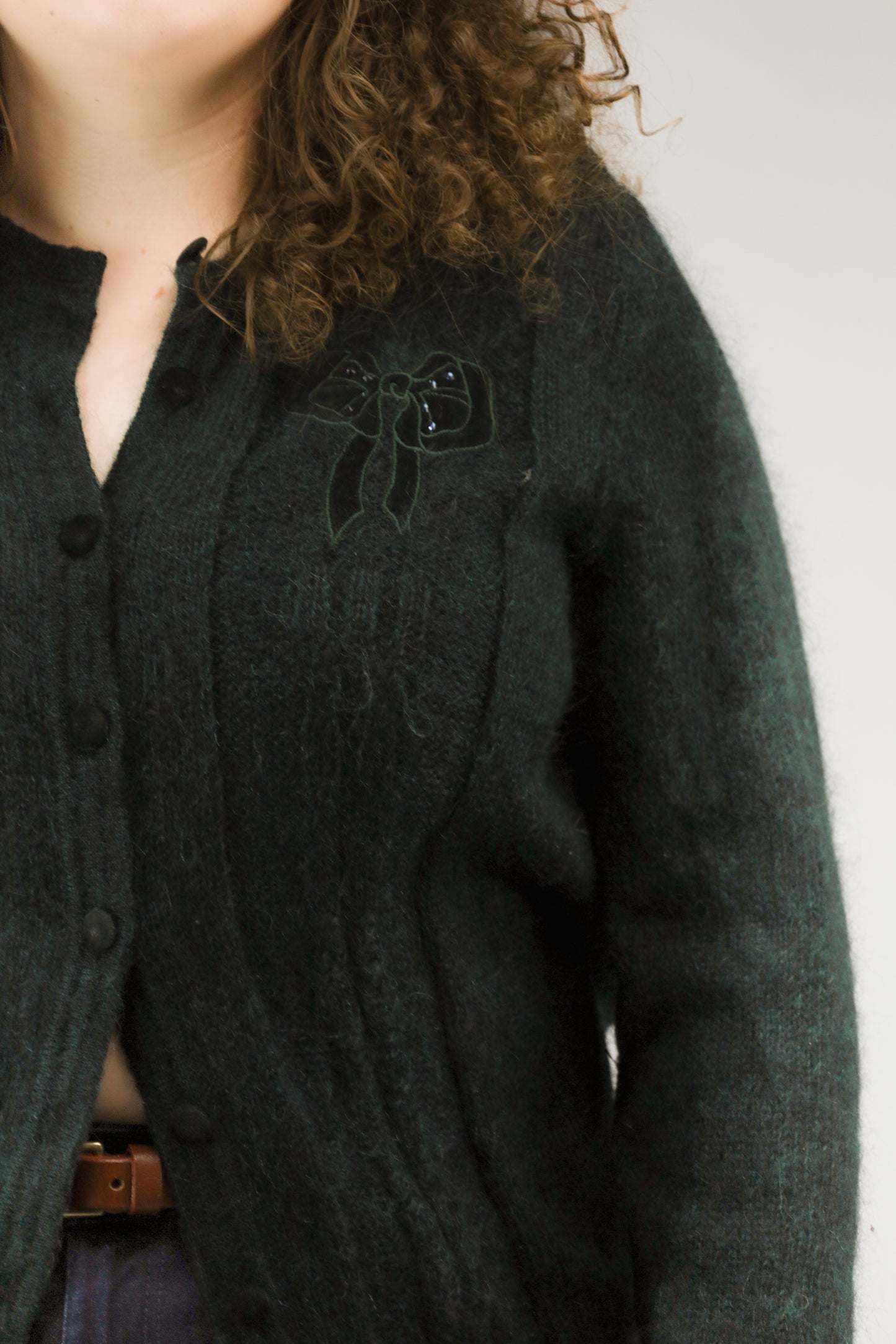 Detail van mohairstructuur en strikapplicatie op emeraldgroen vintage vest