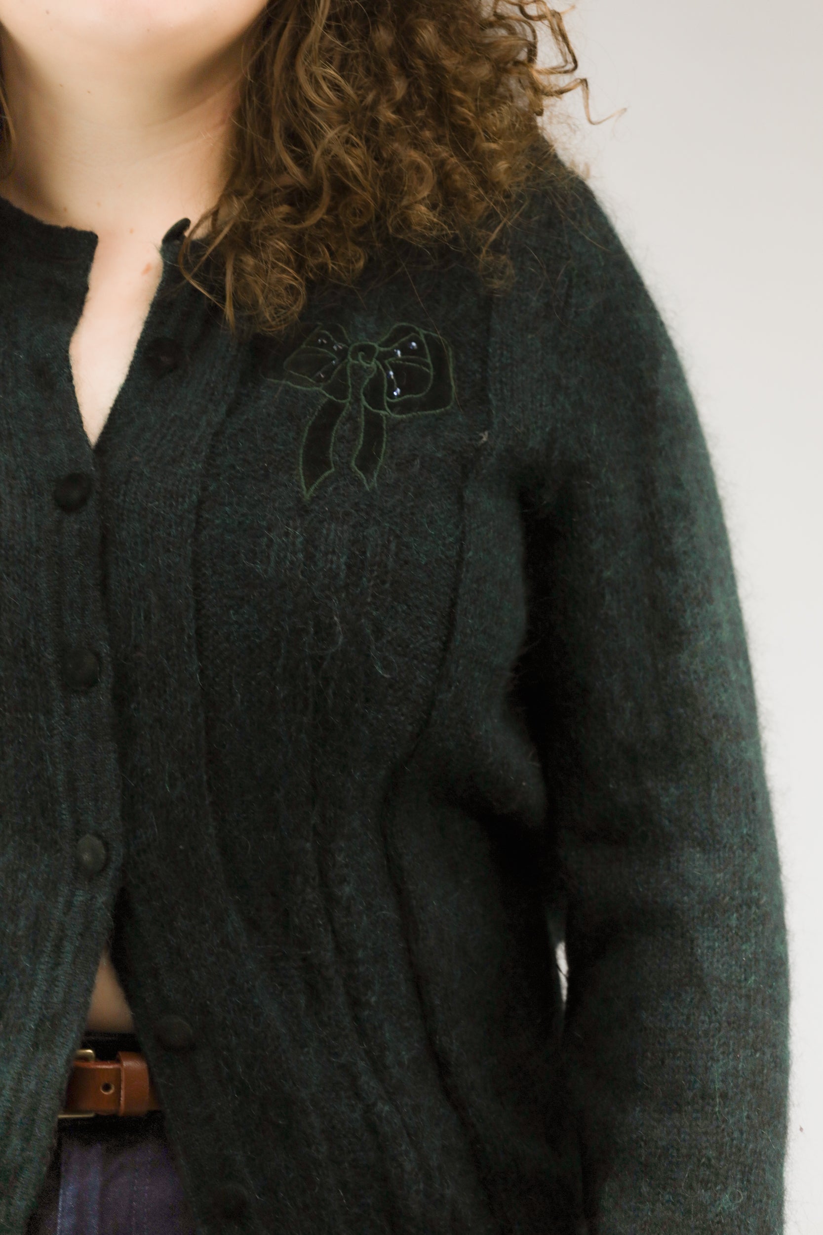 Detail van mohairstructuur en strikapplicatie op emeraldgroen vintage vest