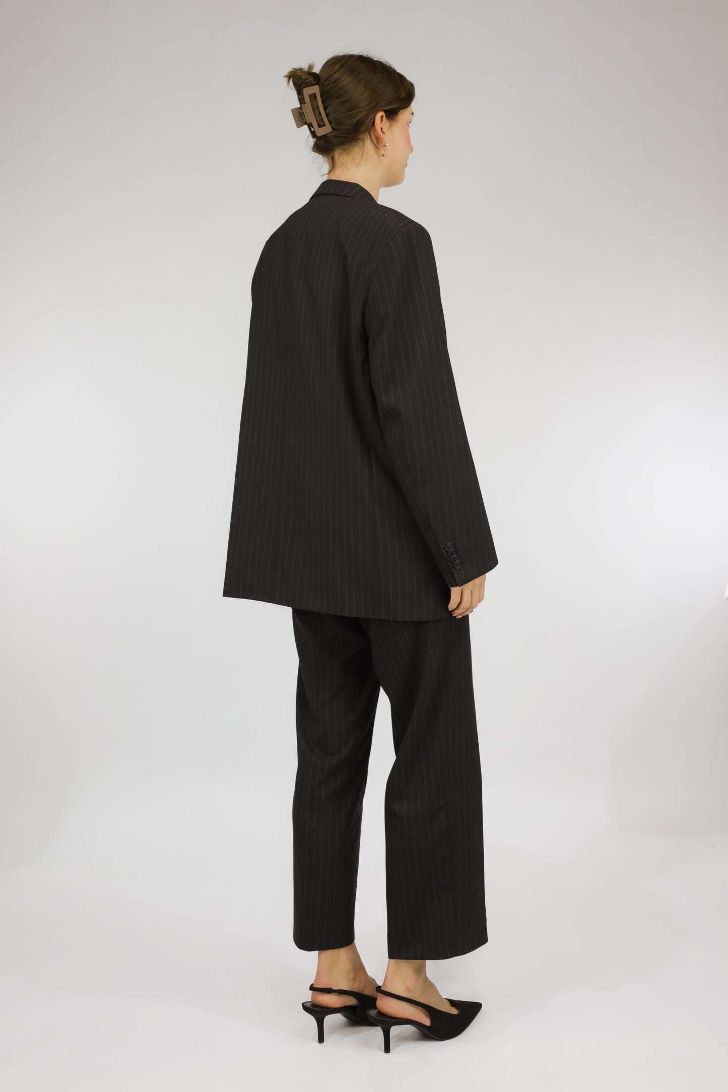 Achteraanzicht van tweedelig donkergrijs vintage pak met krijtstreep