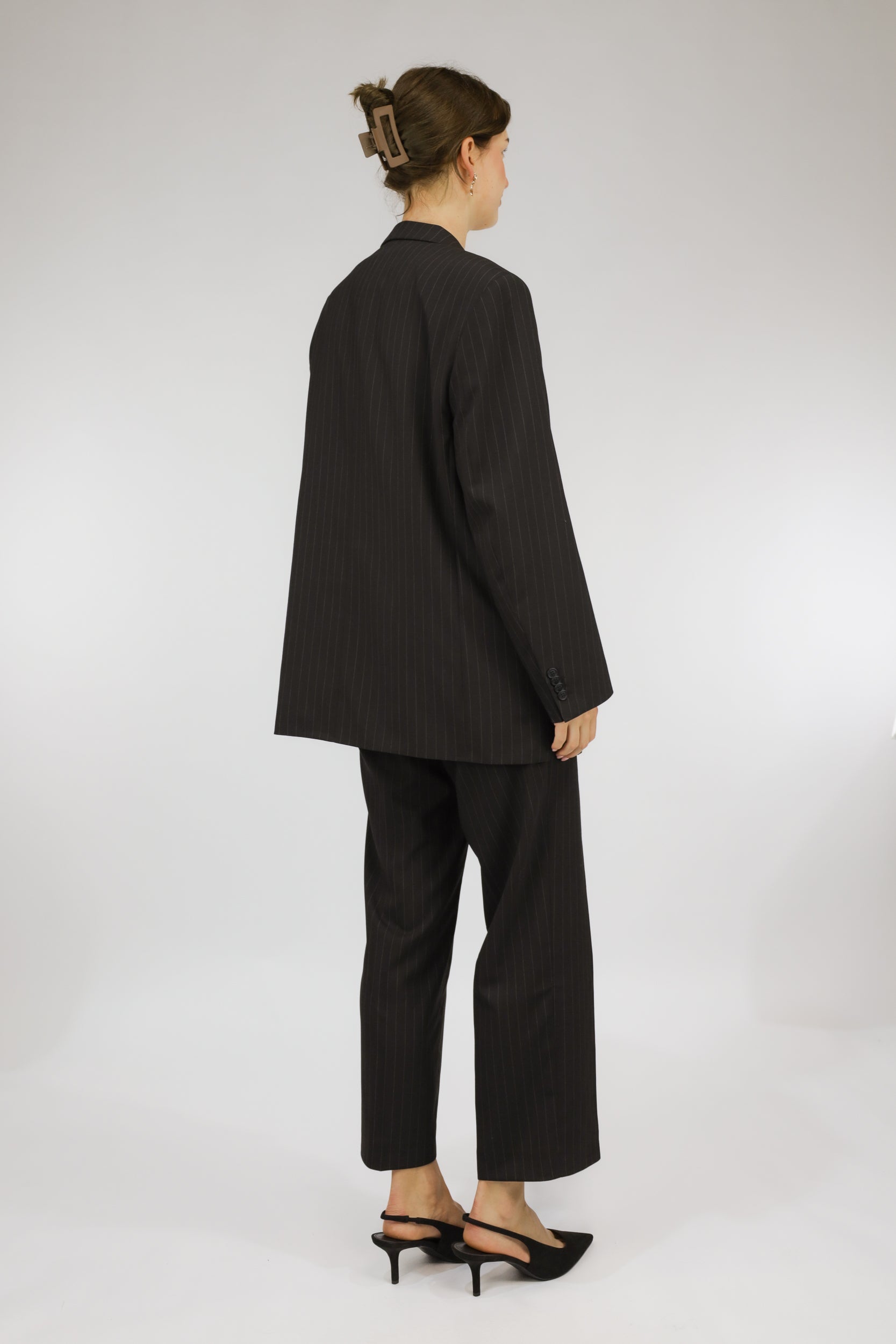 Achteraanzicht van tweedelig donkergrijs vintage pak met krijtstreep