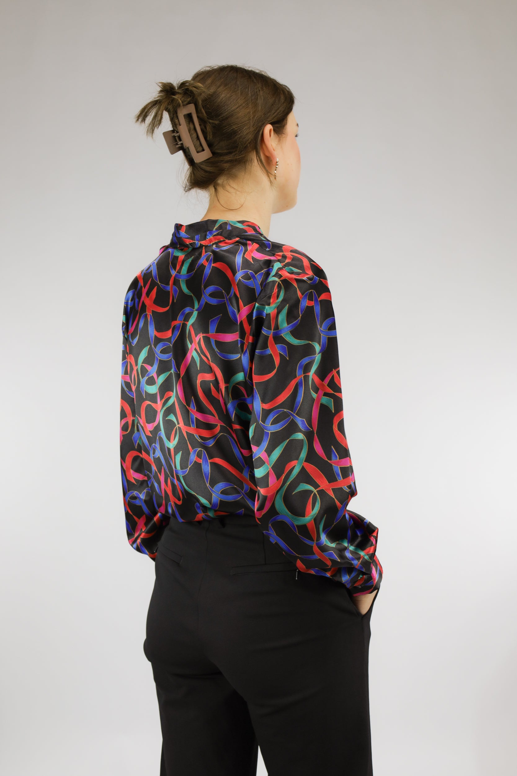 Achteraanzicht van zwarte vintage blouse met kleurrijk dessin