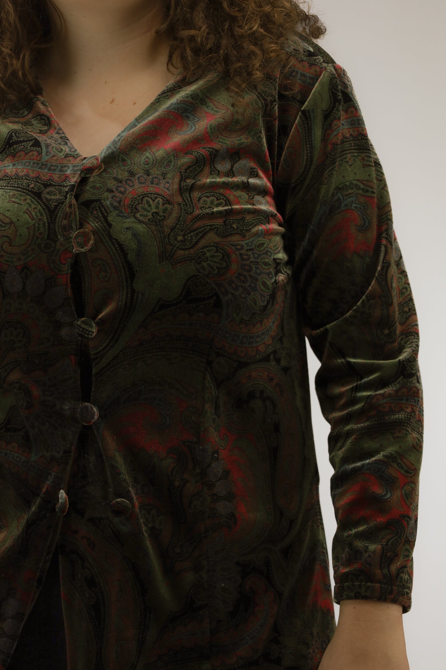 : Detail van velvet stof, paisleydessin en gestoffeerde knoopjes