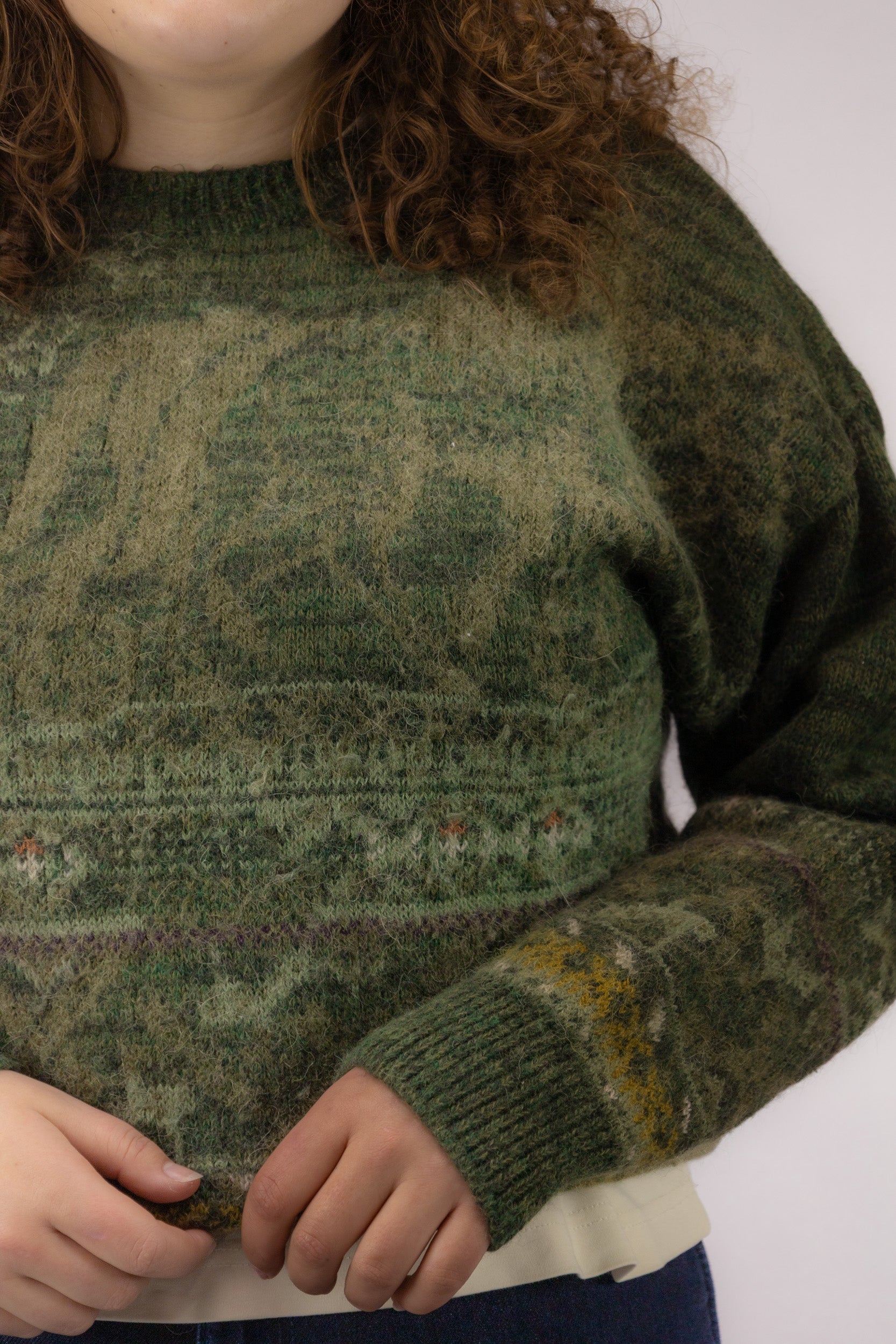 Detail van fijn dun breisel in groene mêlee tinten van vintage cropped trui