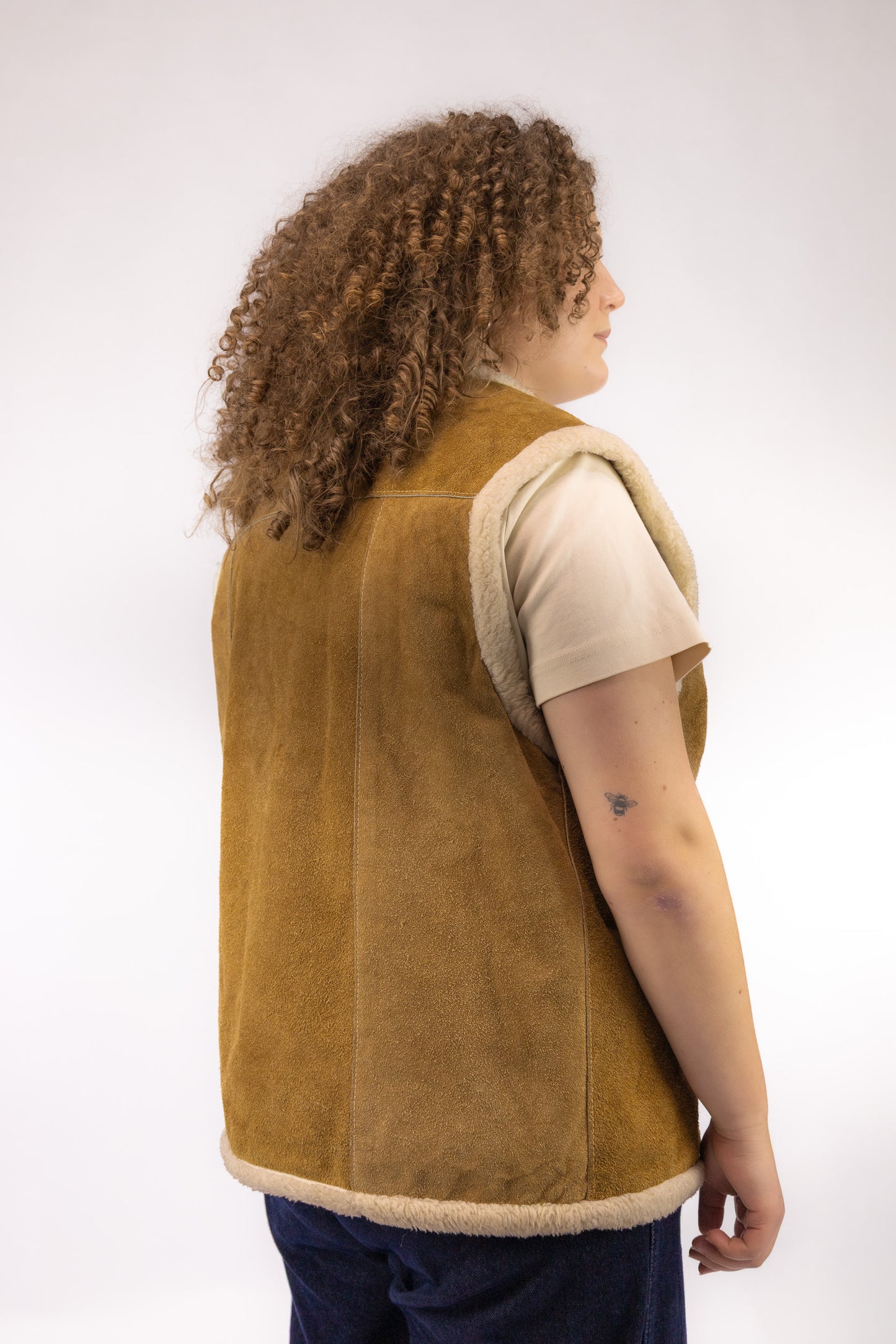 Achterkant van vintage leren gilet in bruin leer met warme wollen voering – achteraanzicht