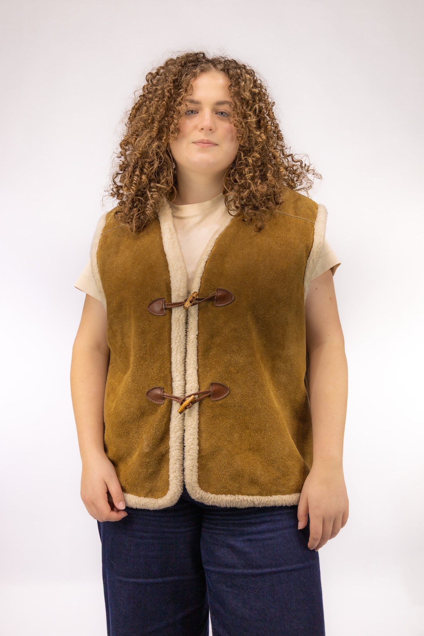 Vintage bruin leren gilet met off-white wollen binnenkant en houtje-touwtje sluiting – vooraanzicht