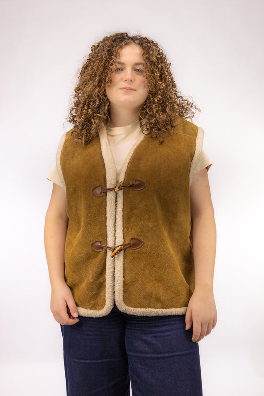 Vintage bruin leren gilet met off-white wollen binnenkant en houtje-touwtje sluiting – vooraanzicht