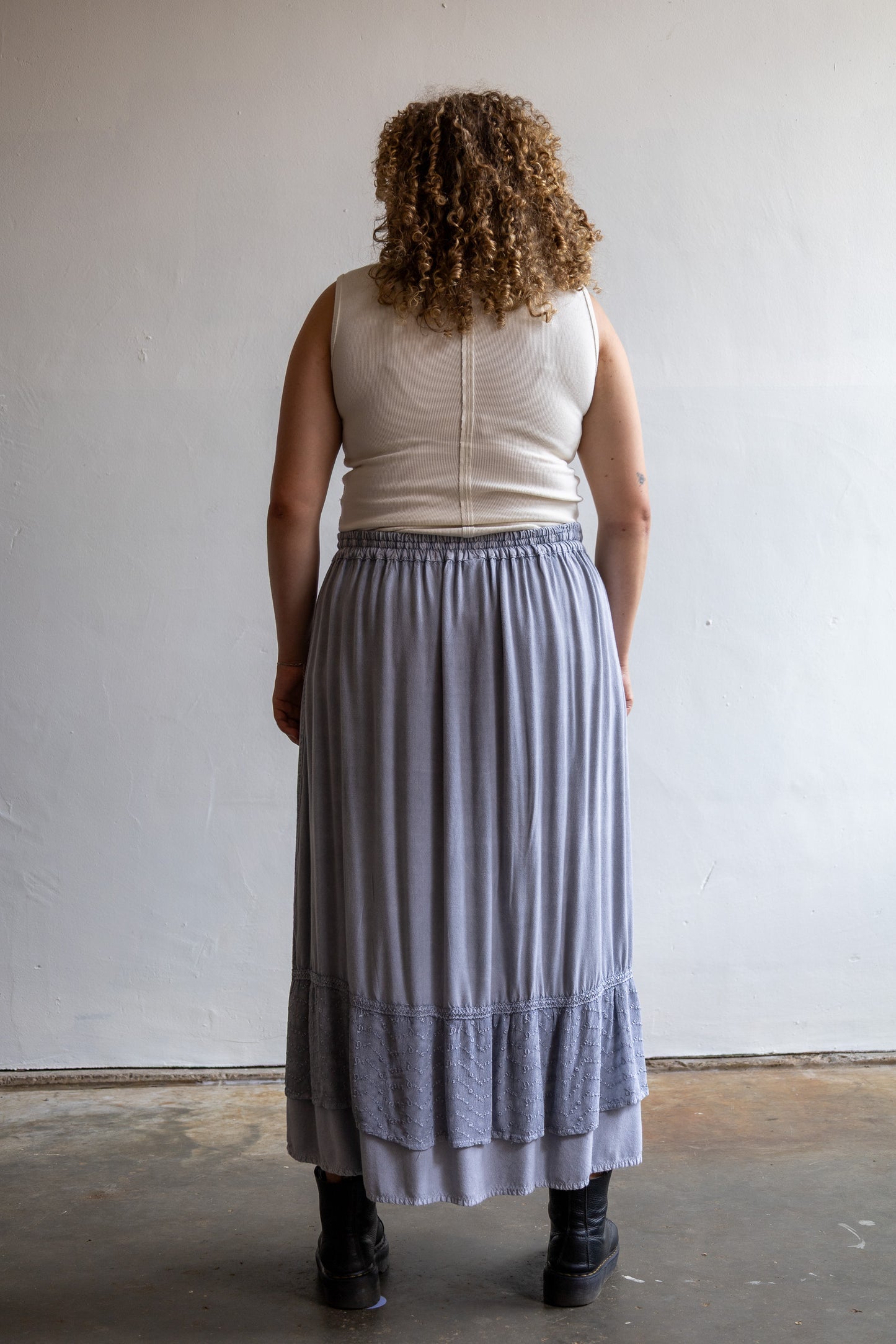 Achterzijde van de vintage grijze maxi rok met elastische tailleband en lange soepelvallende pasvorm.